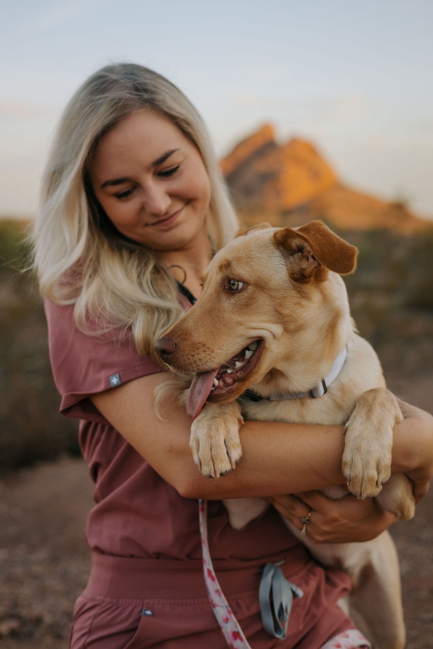 Woman sharing tender moments with her golden retriever dog during an outdoor photoshoot.