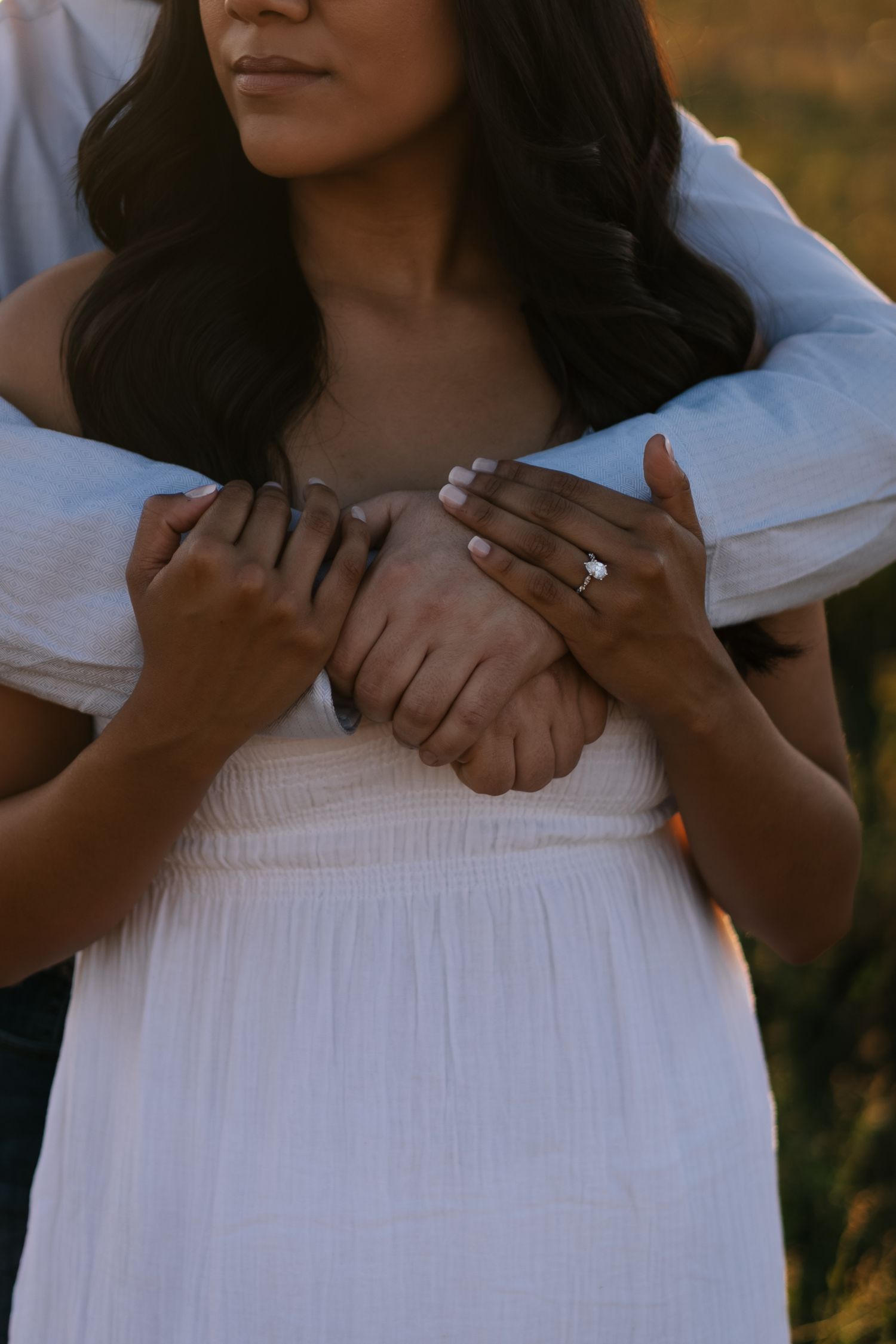 Close-up shots of hands holding and embracing in a white dress.