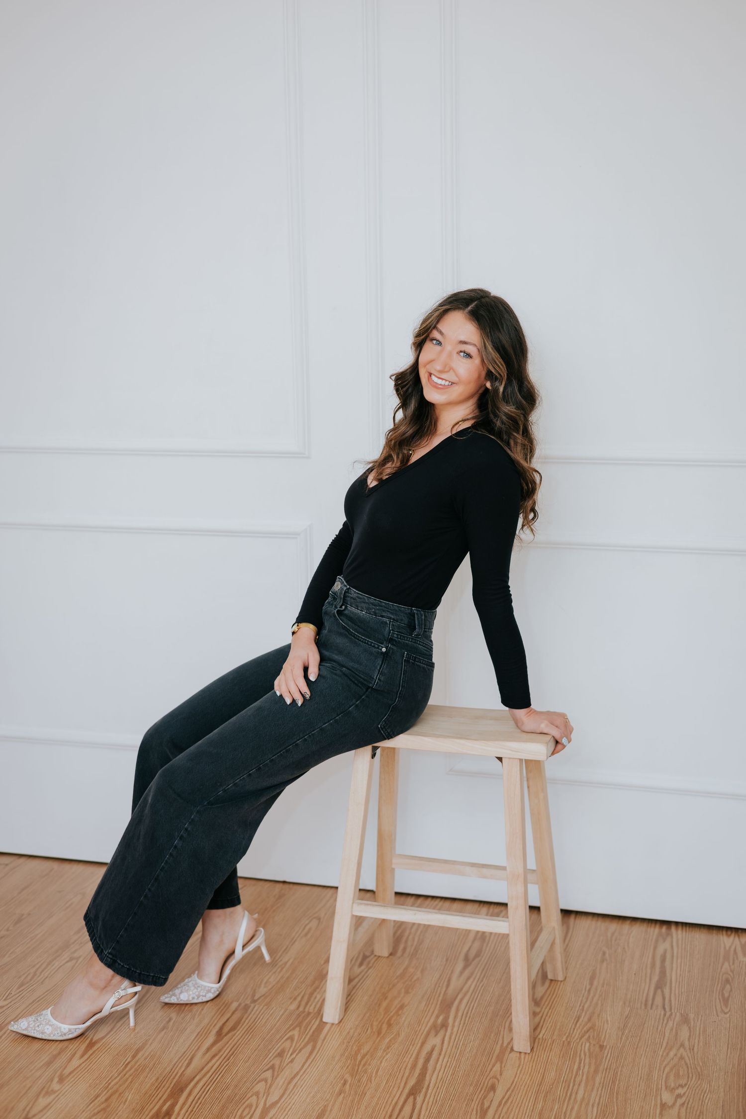 A series of poses showing someone sitting on a wooden stool against a white wall.