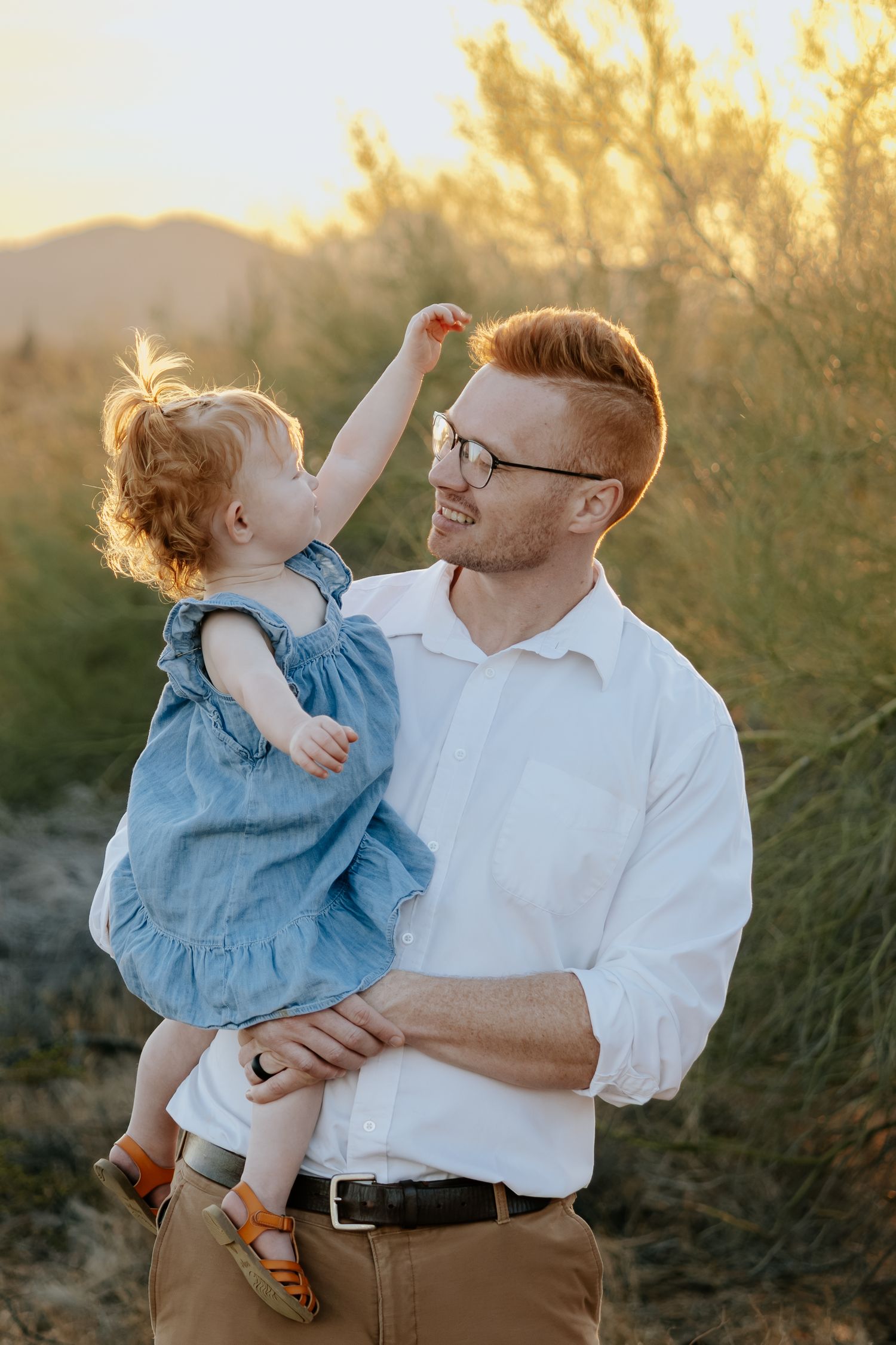 A joyful outdoor portrait captured at golden hour in a desert setting.