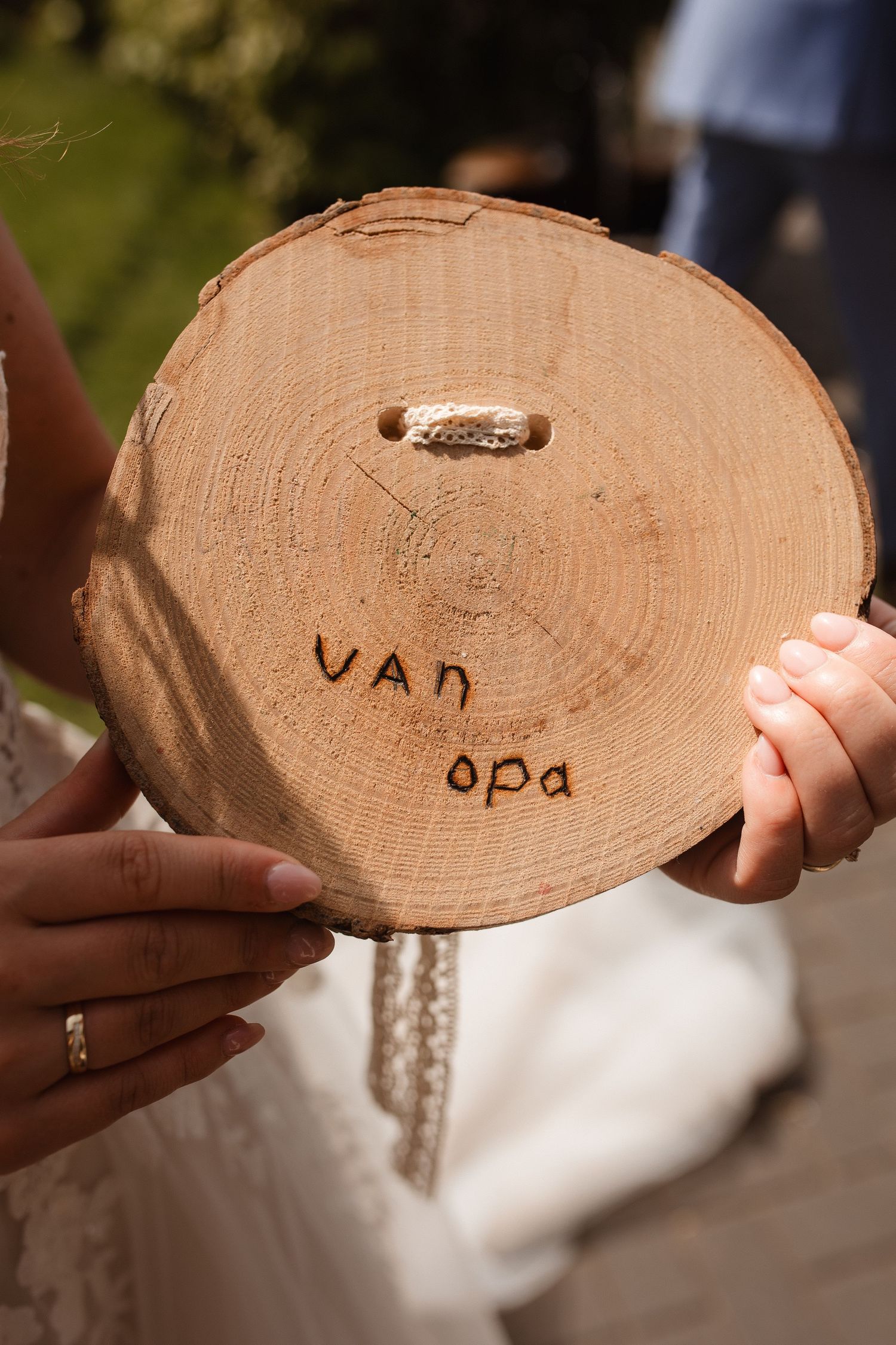 Wooden log slices with handwritten text serve as rustic wedding decor elements.