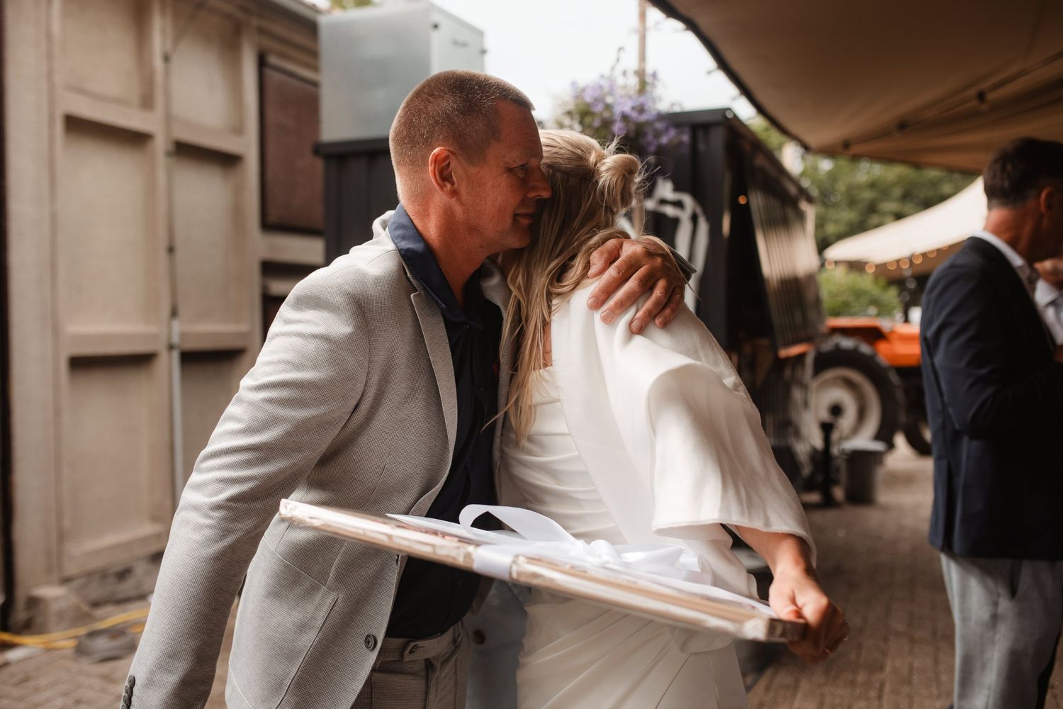 Two people sharing an intimate moment near a vintage truck at an outdoor event.