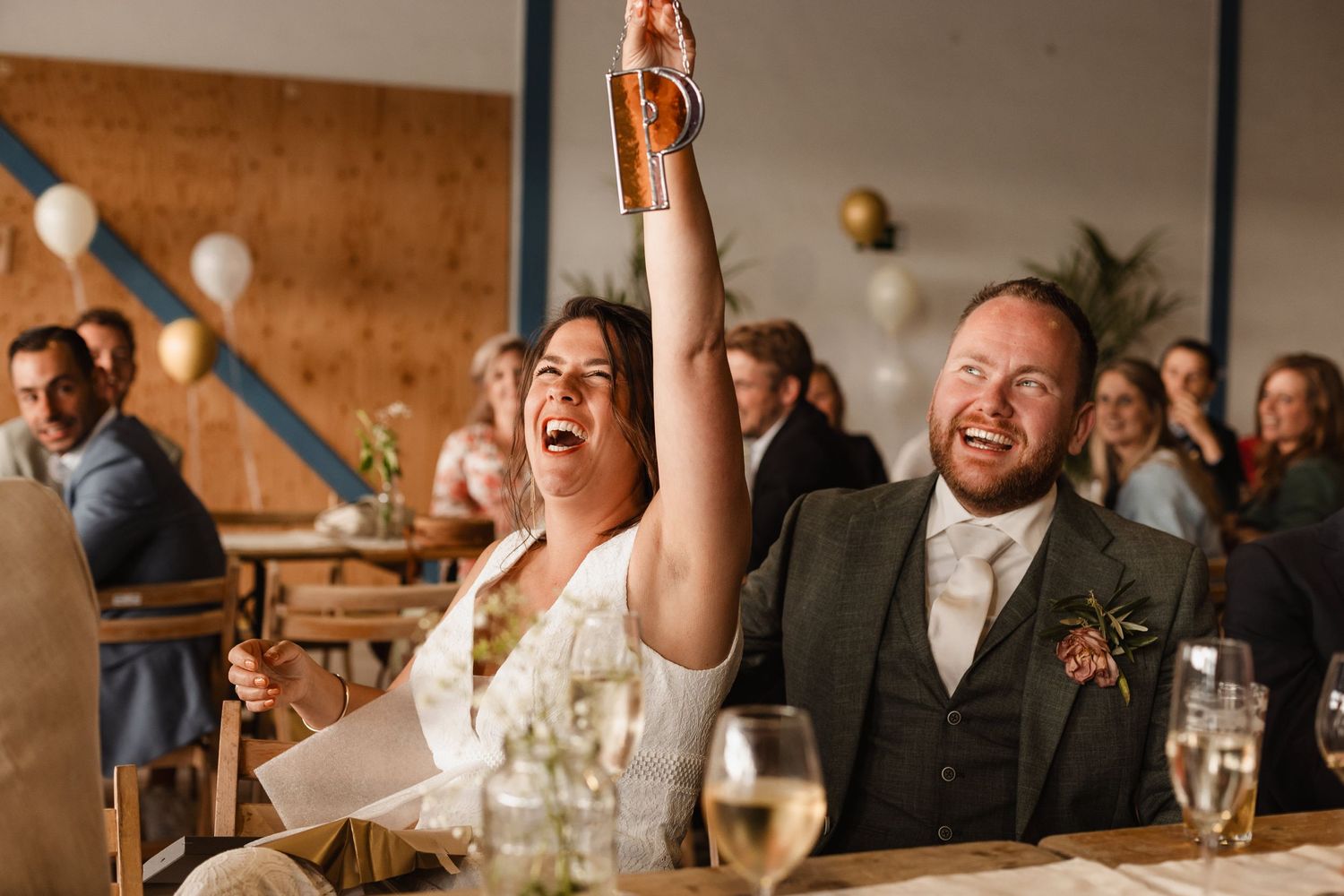 Guests share animated expressions of joy during wedding reception festivities.