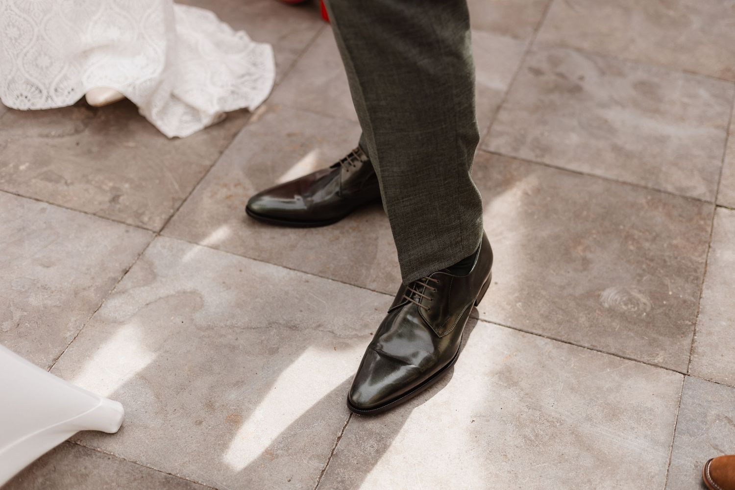 Close-up of wedding couple's feet during first dance on stone floor.
