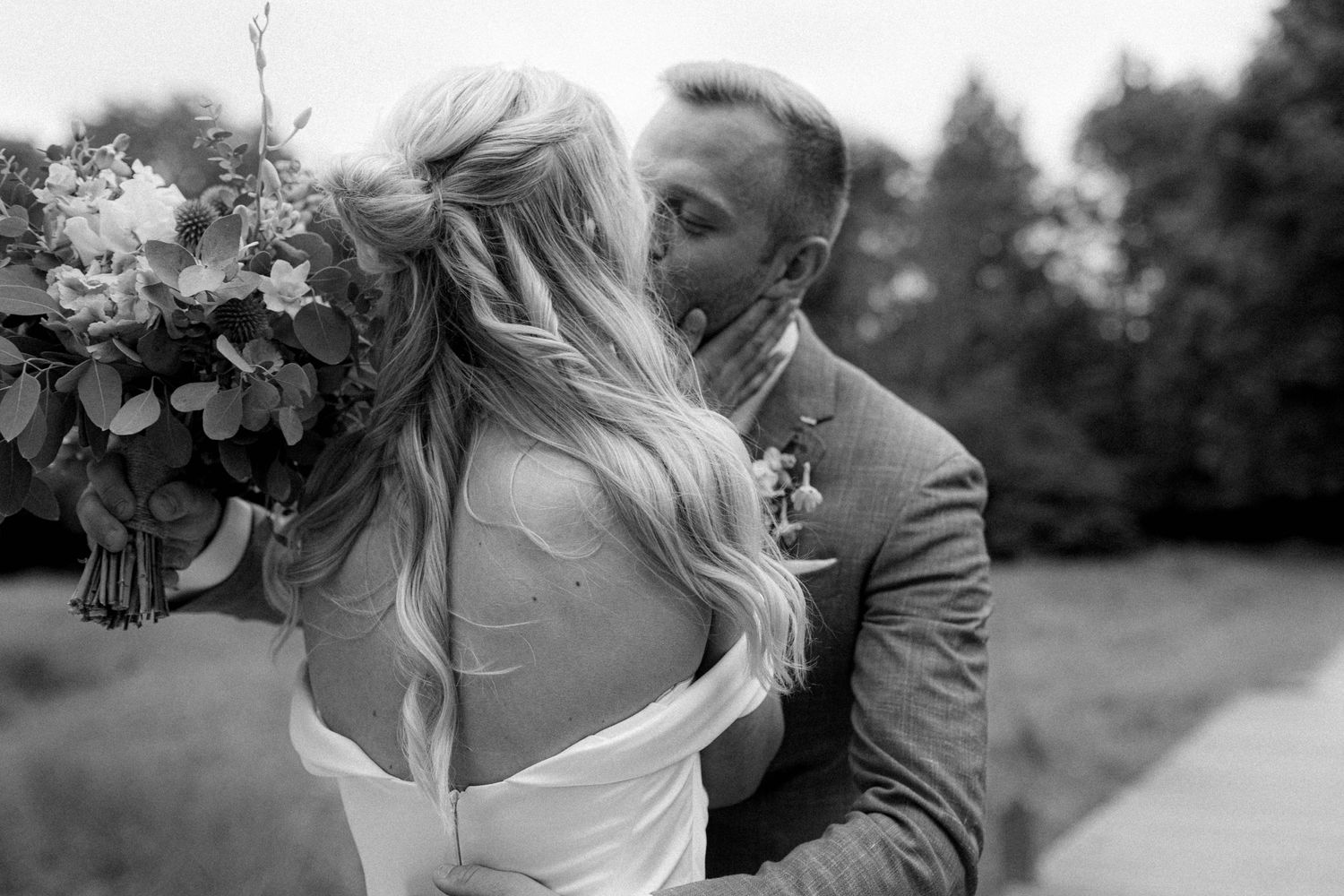 Black and white romantic wedding portraits in an outdoor setting.