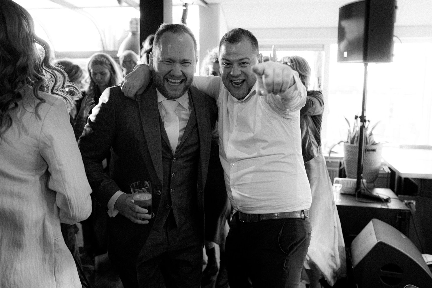Black and white candid shots show genuine laughter during wedding celebration.