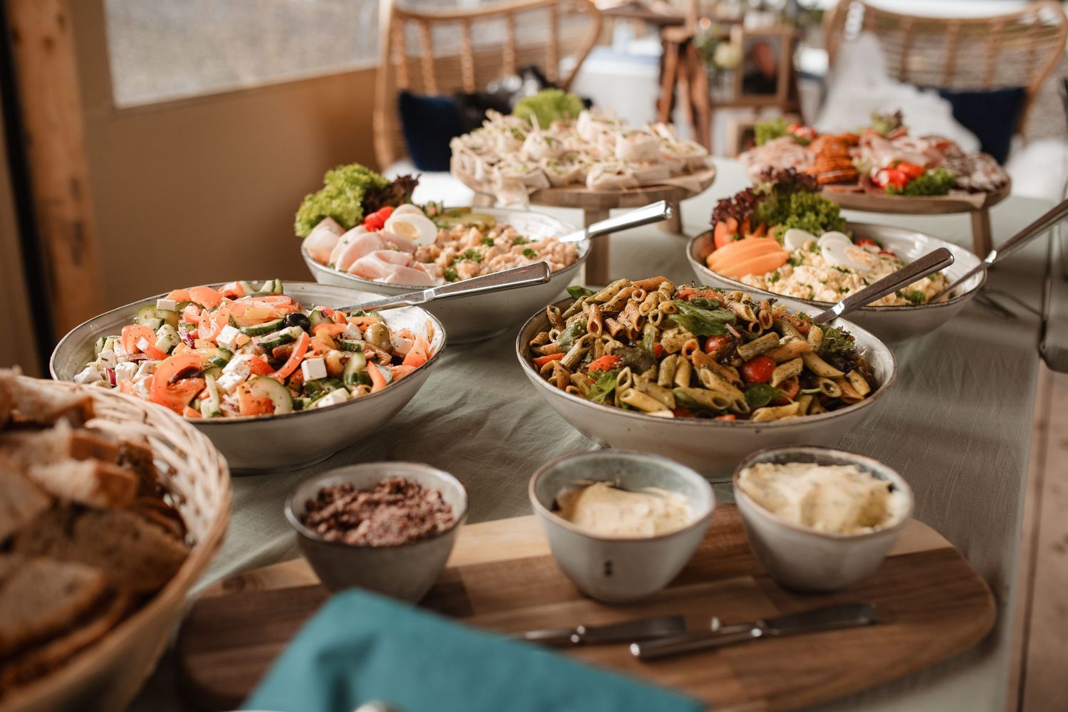 Buffet table spread with various dishes including salads and sides in serving bowls.