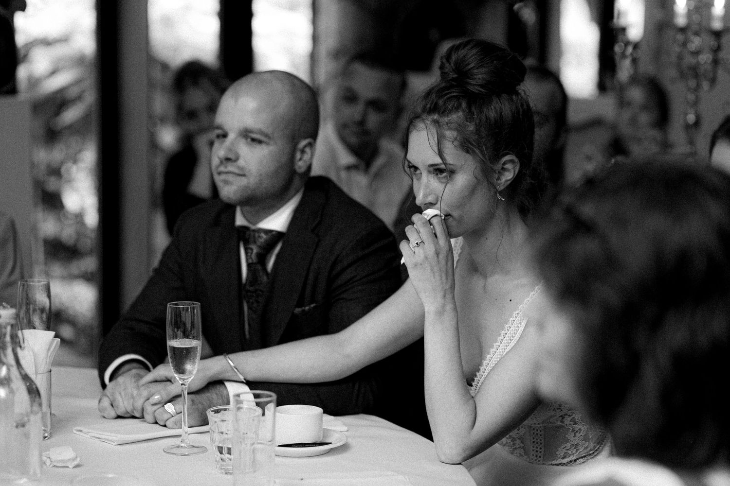 Guests seated at elegant wedding reception tables during dinner service.