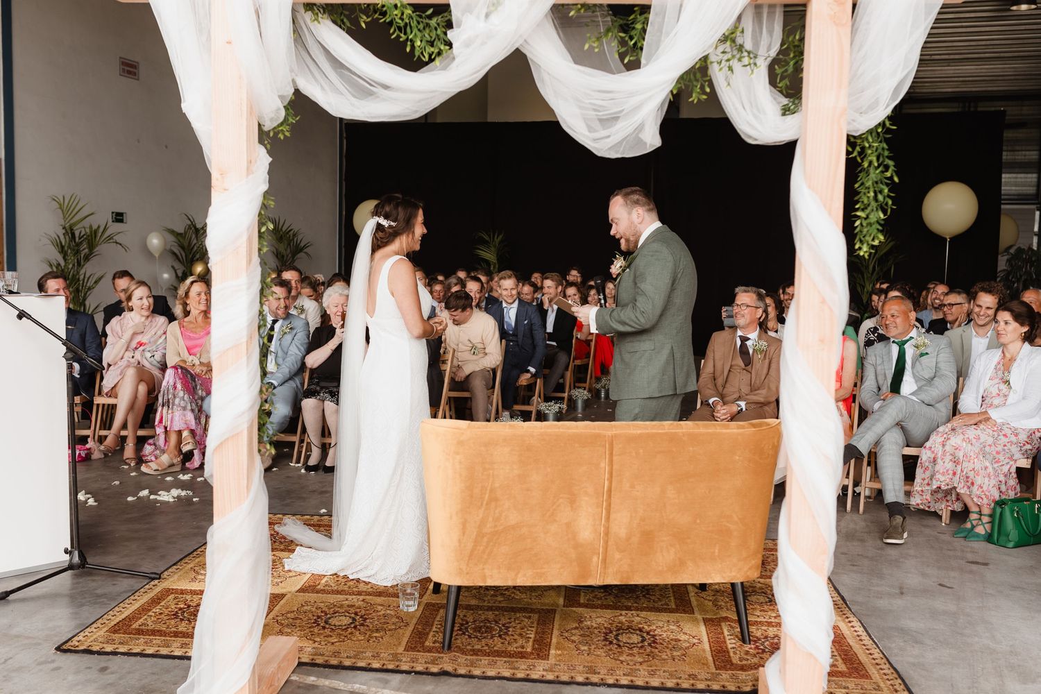 An elegant wedding reception setup with white draping and decorative elements.