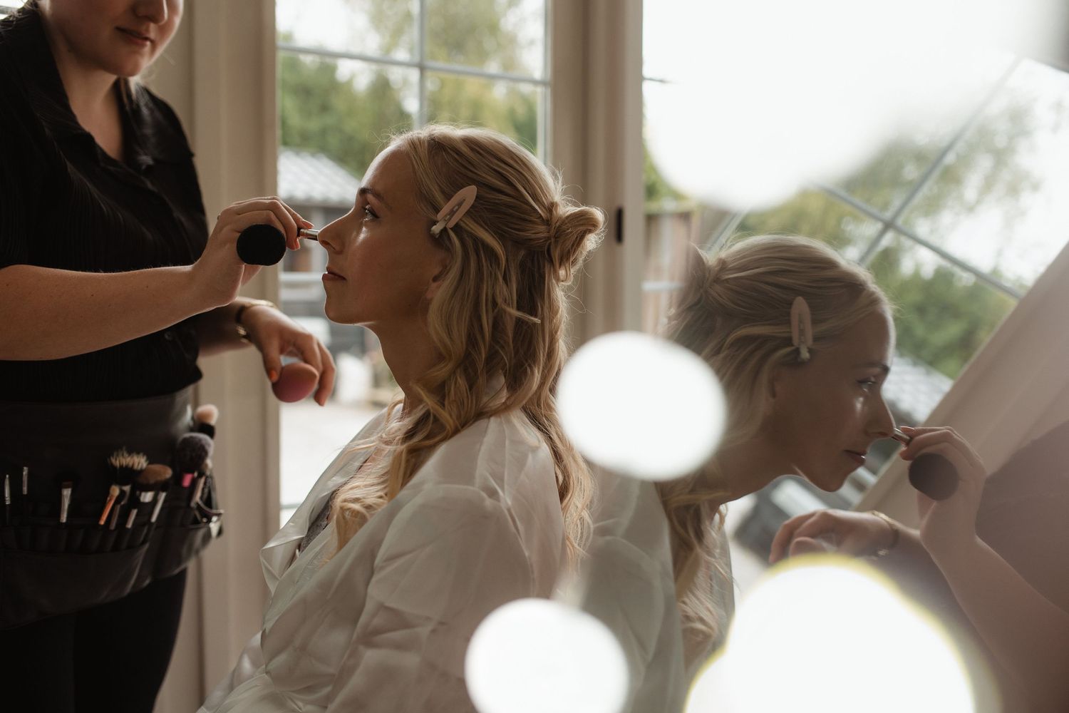 Wedding preparation scene with styling taking place in a bright room.
