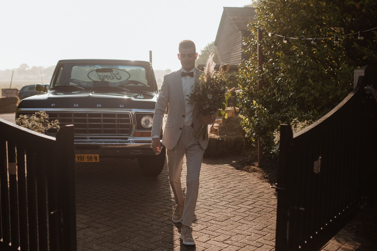 Outdoor wedding scene with vintage truck and natural sunlight.