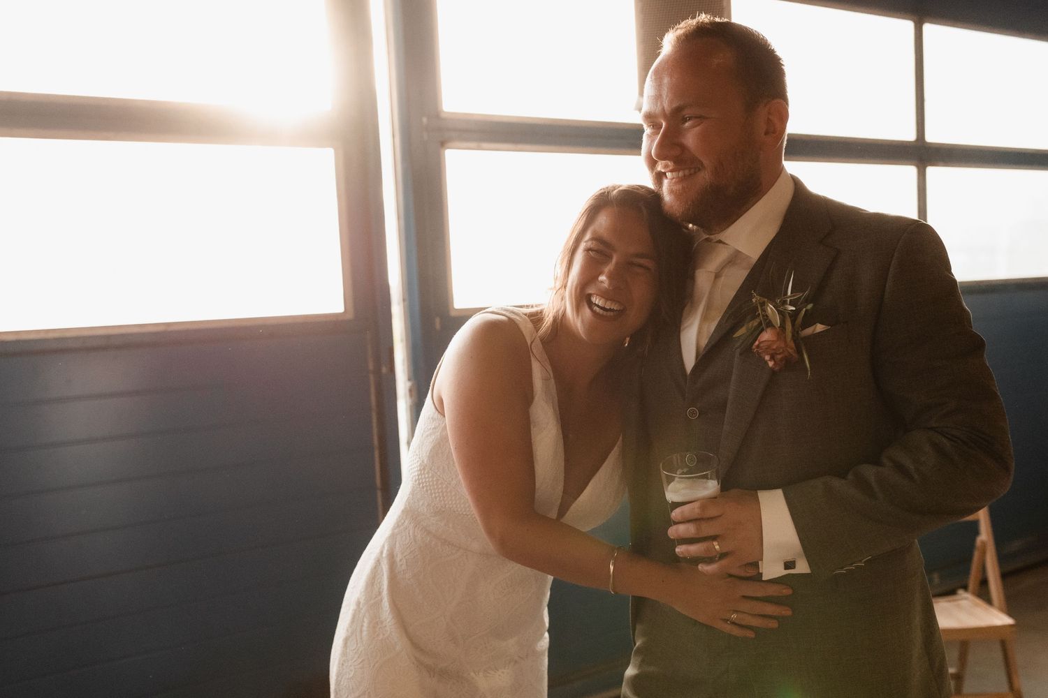 Sunlit wedding reception captures joyful candid moments between guests.
