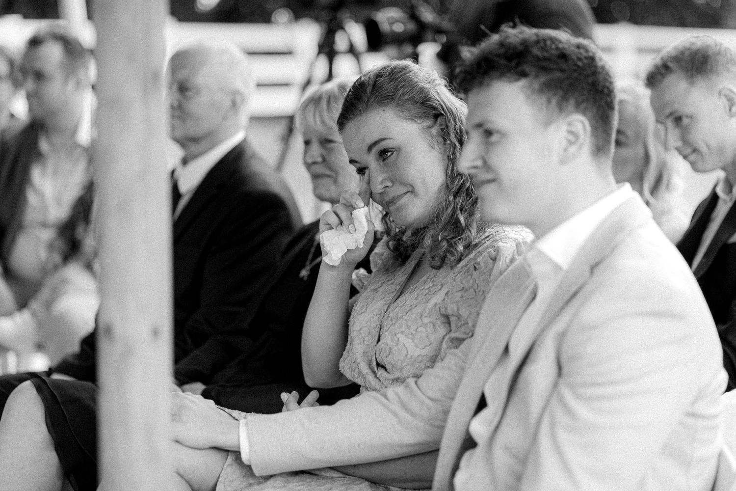 Wedding guests react emotionally during ceremony speeches.
