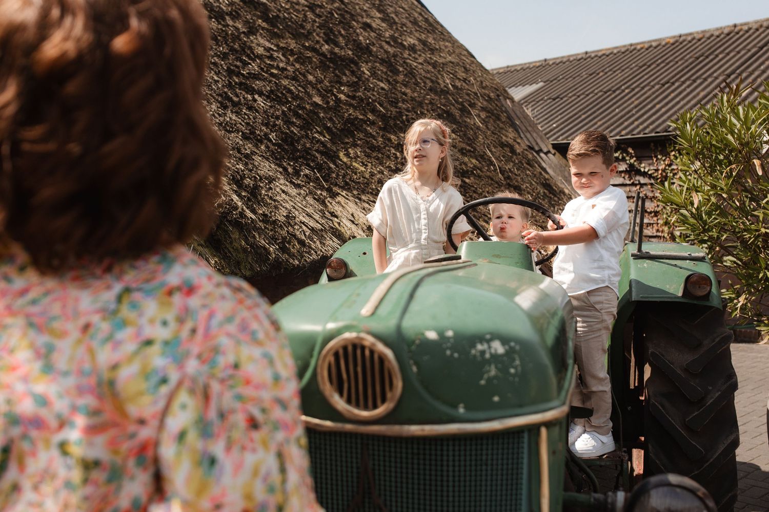 Guests gather around a vintage green car during an outdoor celebration.
