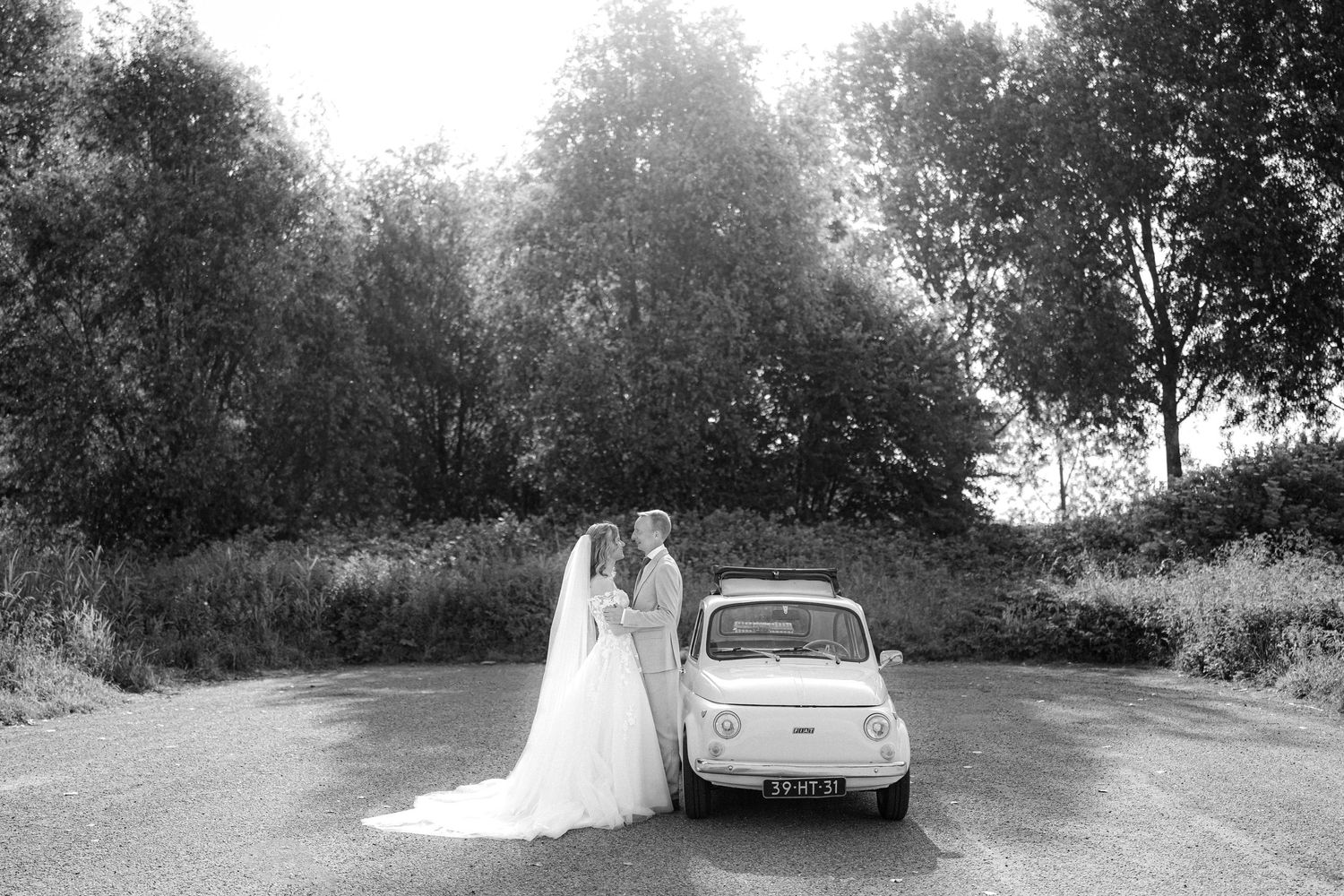 Bruiloft foto met een trouwauto Fiat tijdens de fotoshoot
