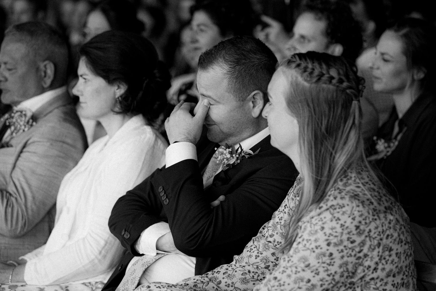 Wedding guests watching intently during an emotional ceremony moment.