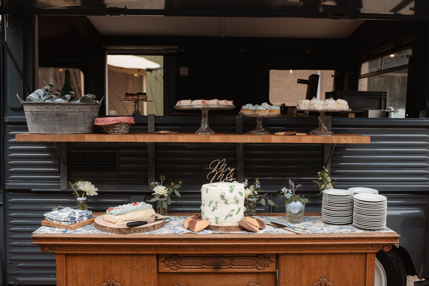Wedding reception table setup with white plates and rustic decor.