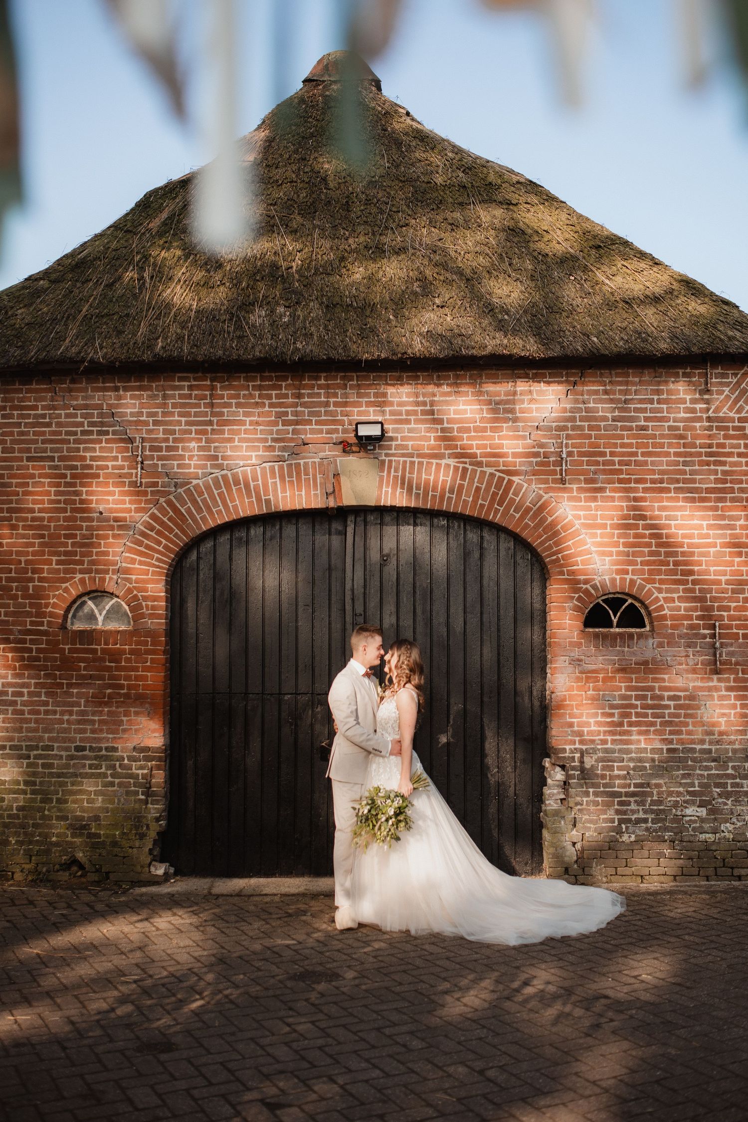 Romantic photo session against rustic brick wall with arched doorways.