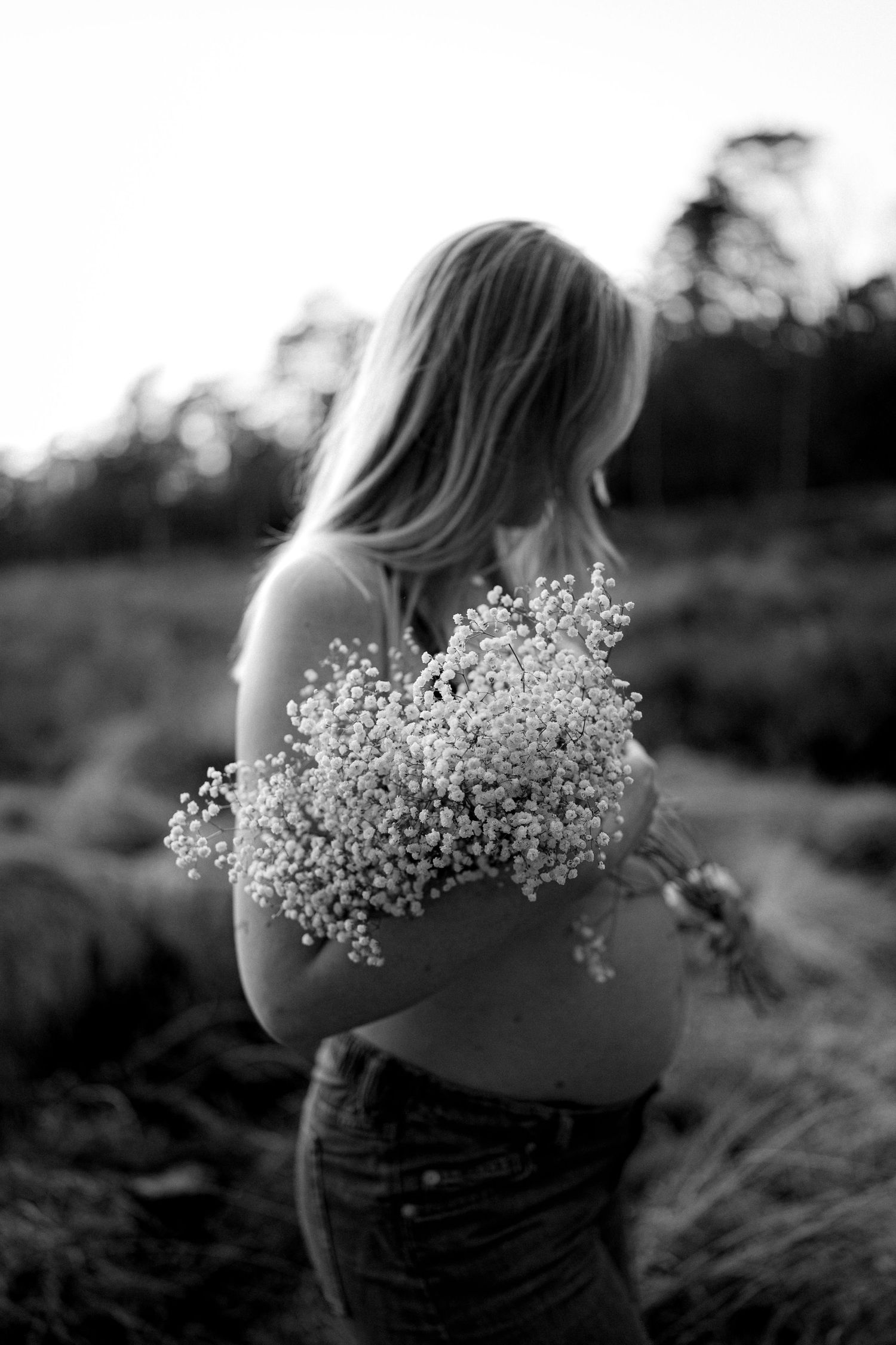 Artistieke foto van de zwangere buik met een bos bloemen