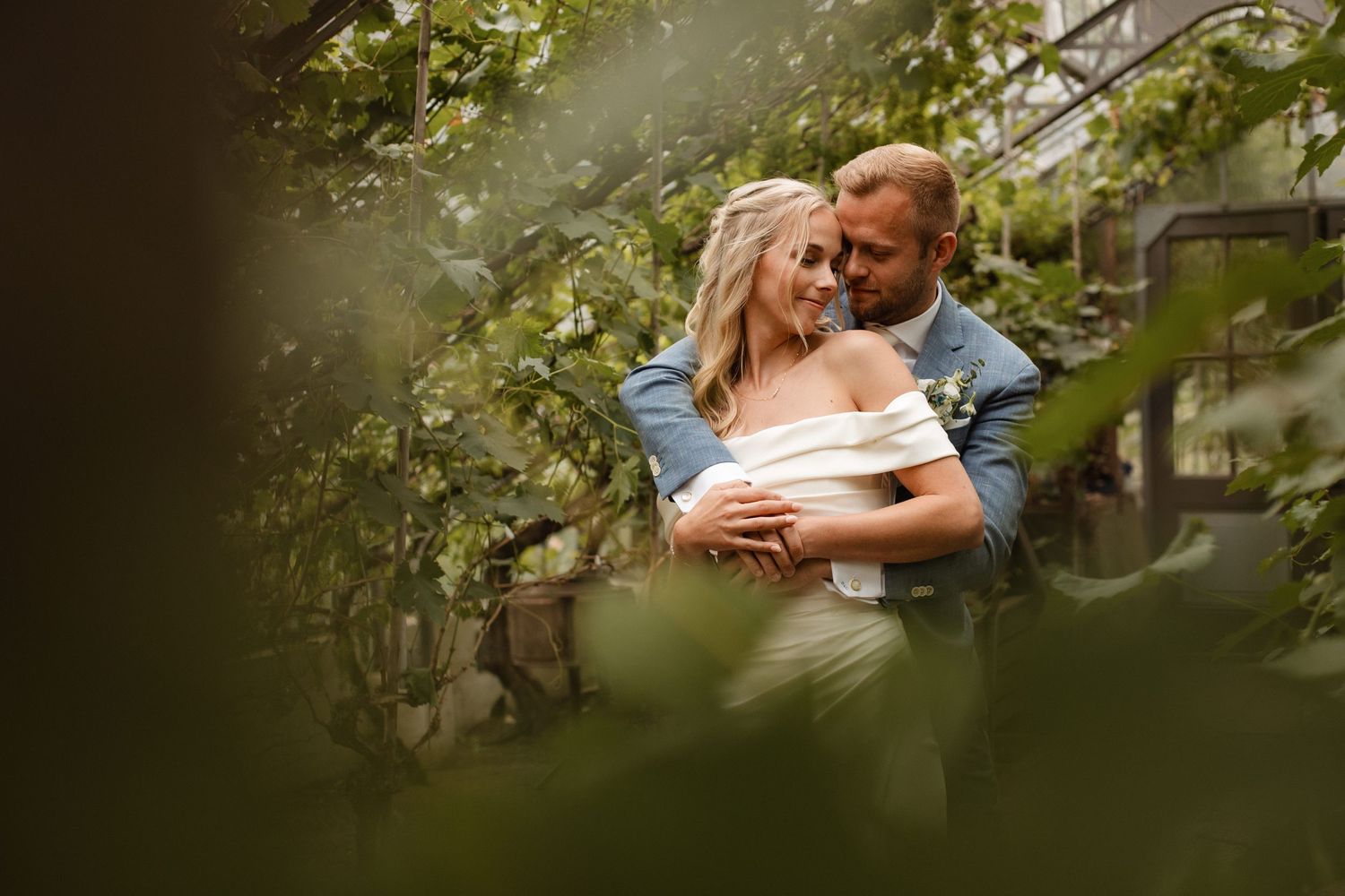Intimate wedding moments captured through leafy foliage.
