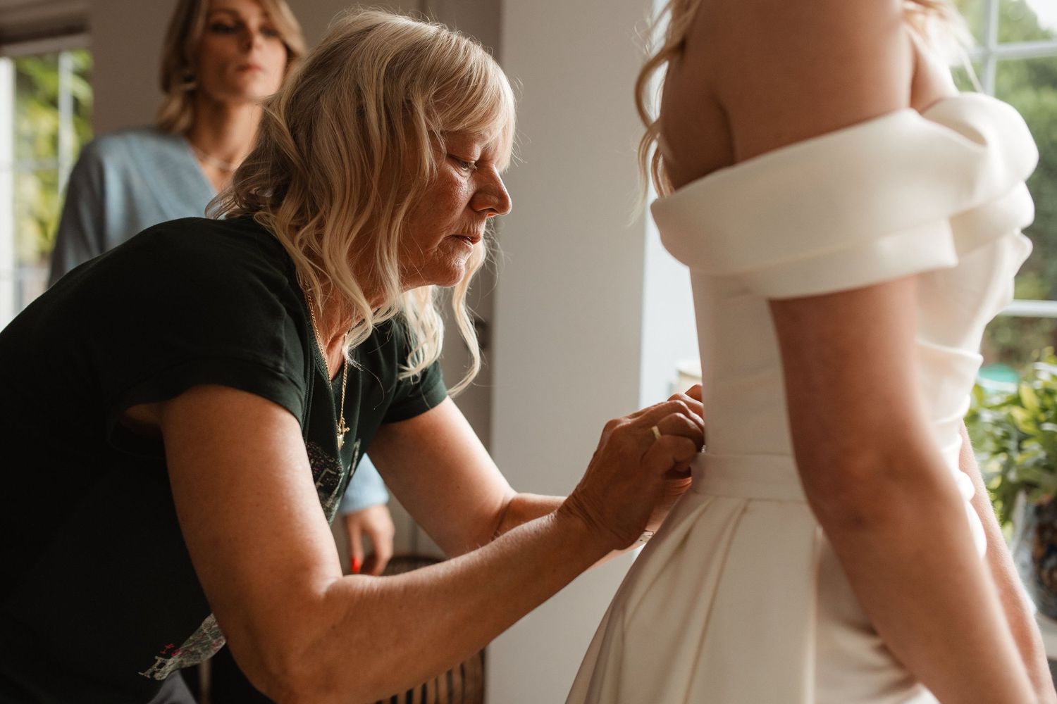 Final dress adjustments being made before the wedding ceremony.