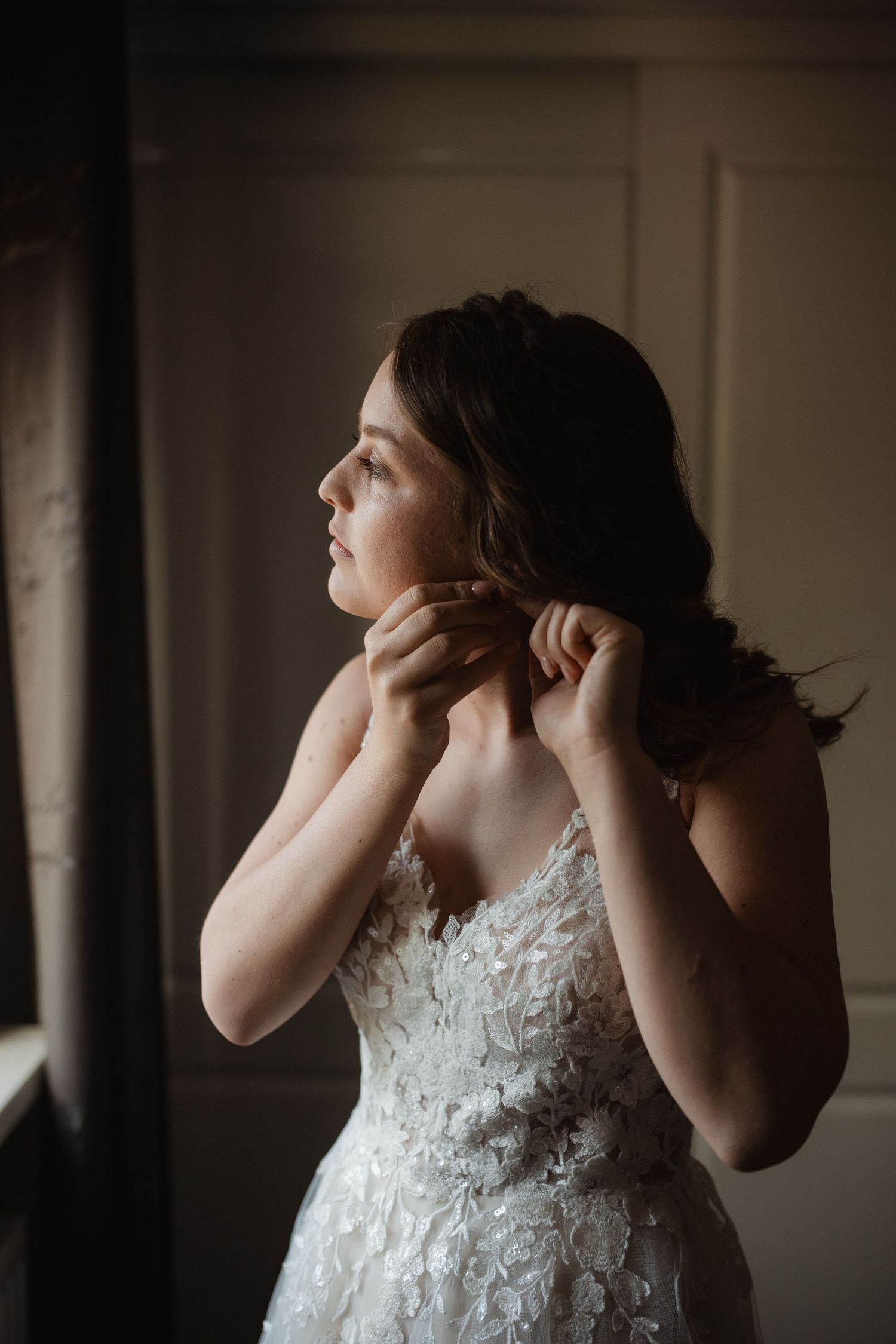 Close-up shots of a bride getting ready in a white lace wedding dress against a dark background.