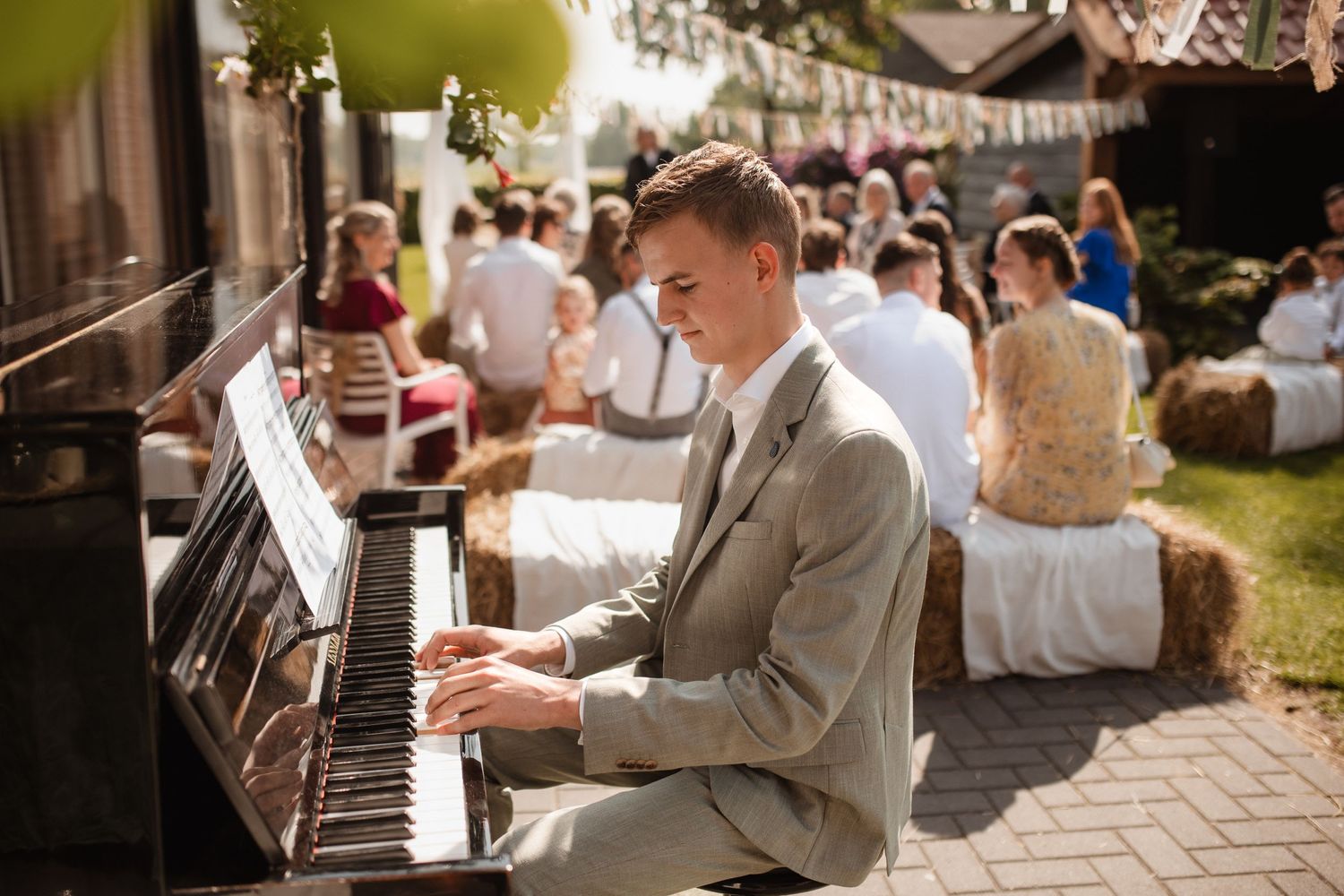 A piano player performs during an outdoor wedding celebration.