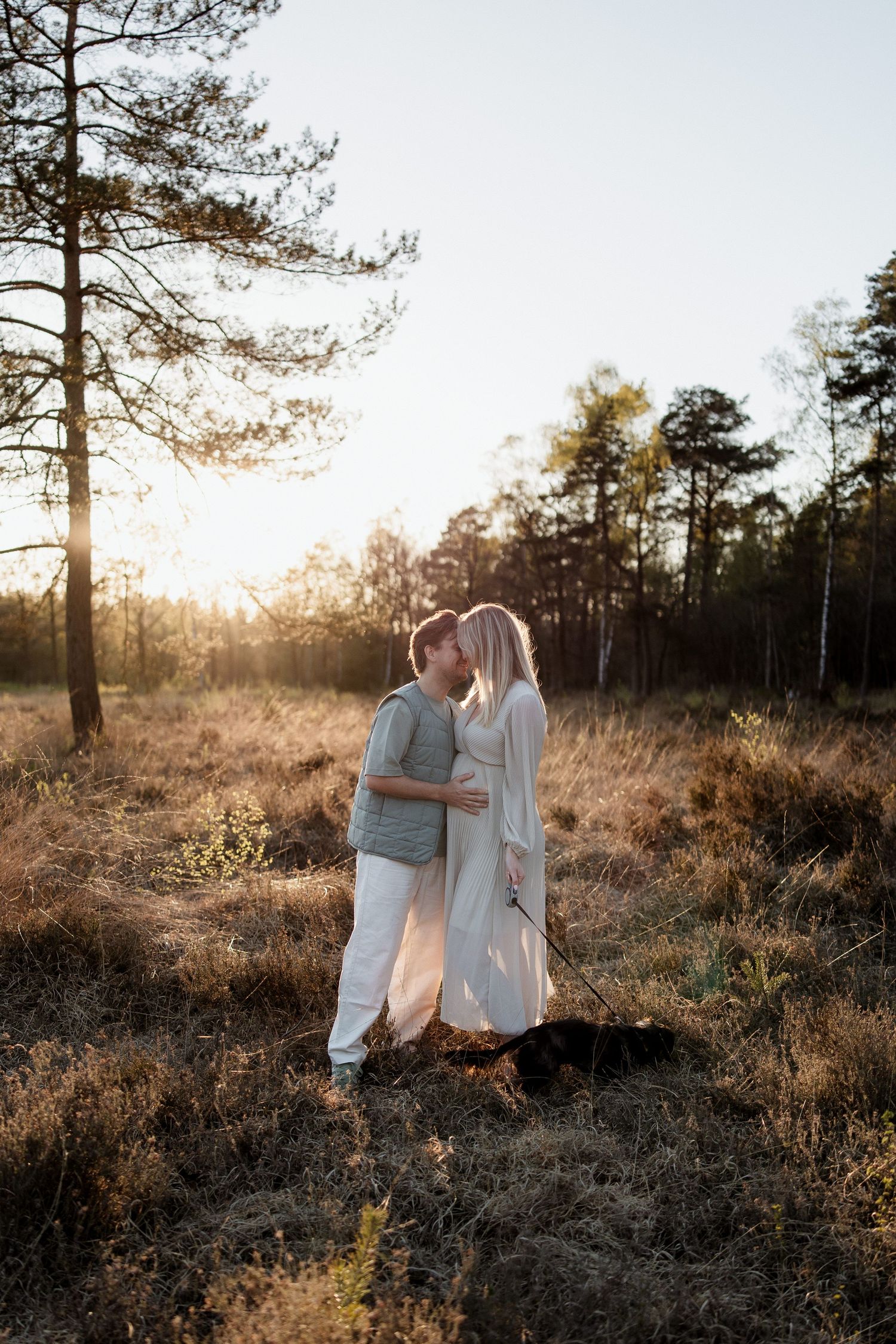 Een foto van een zwangere vrouw met haar partner op de hei in Leusden