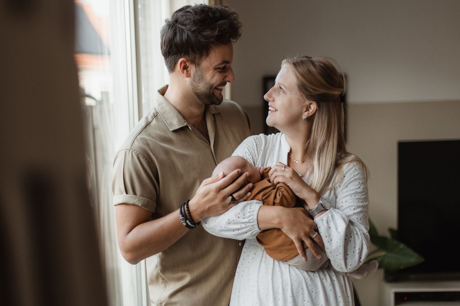 Intimate indoor lifestyle photography session with soft window lighting and muted tones.