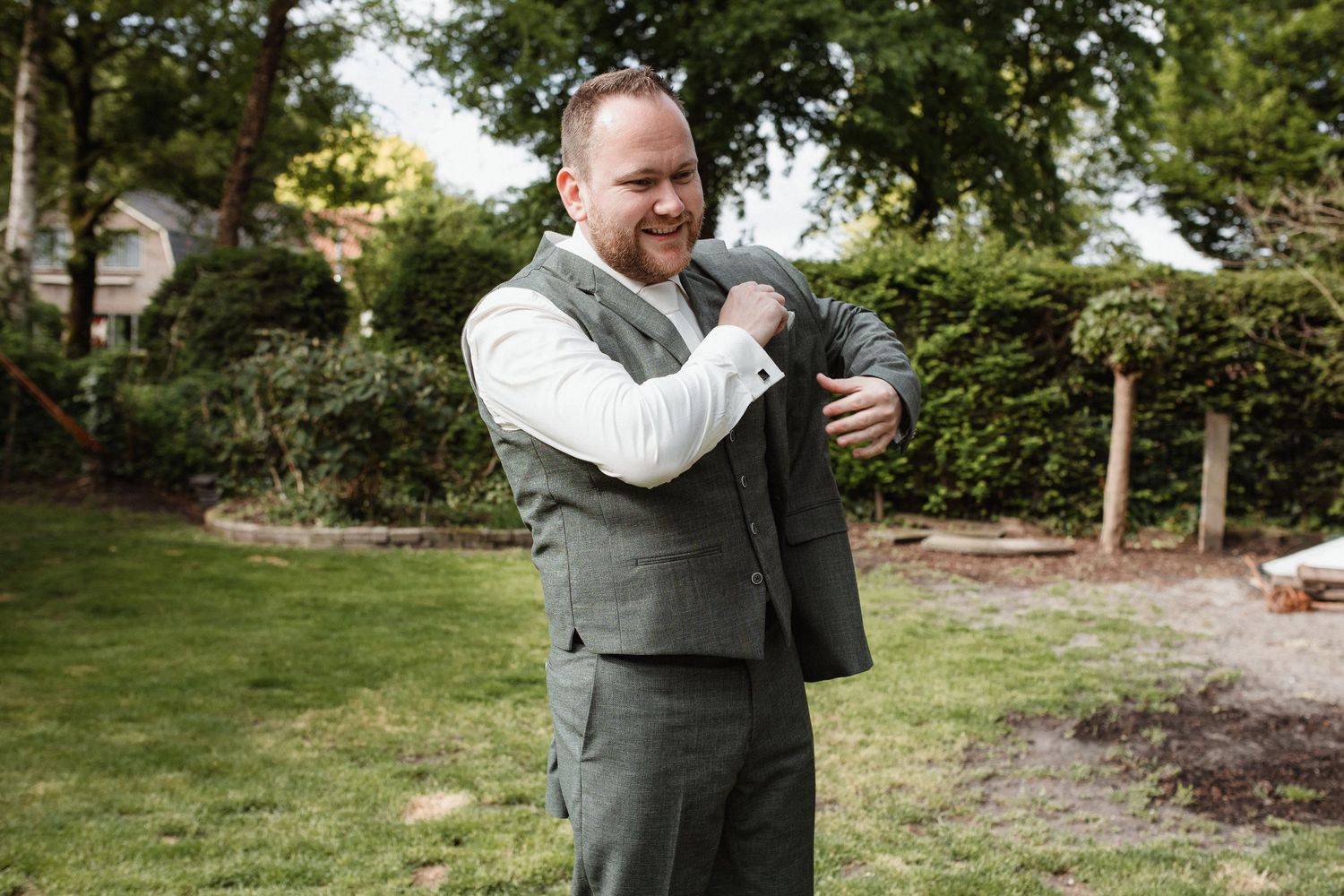 Outdoor wedding celebration with guests embracing in a garden setting.