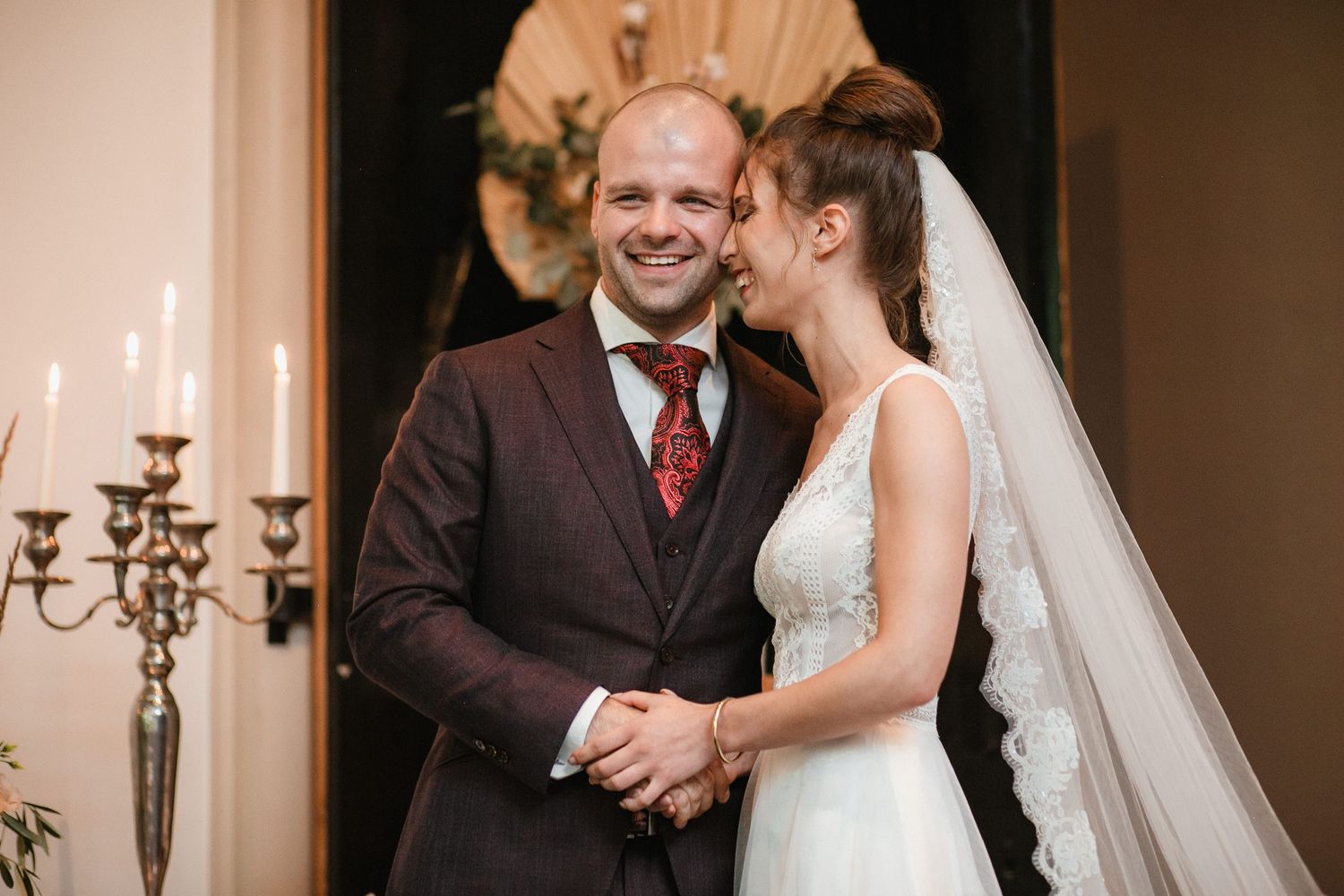 Intimate wedding ceremony moment captured in warm lighting with decorative candelabras.