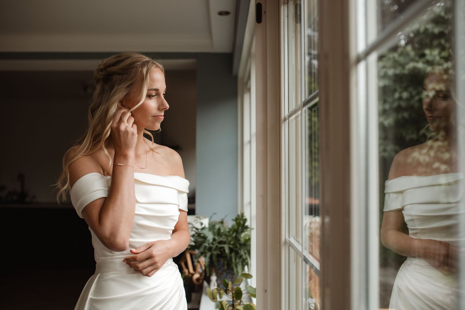 Elegant indoor bridal portraits by sunlit windows in a bright space.