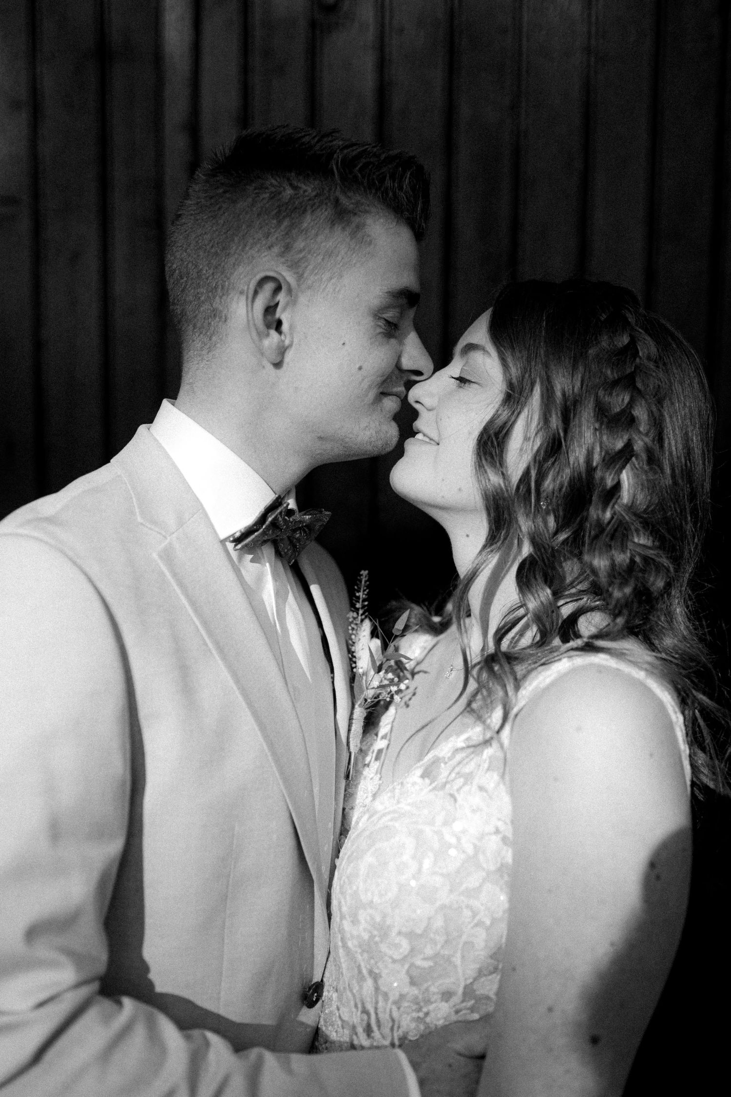 A romantic moment captured in black and white against a dark background.