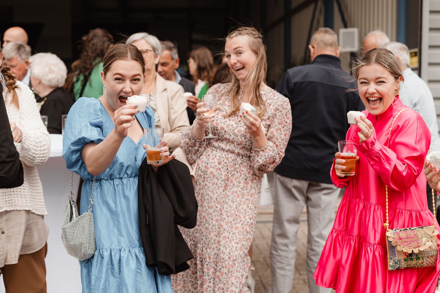 Wedding party members in colorful dresses sharing joyful moments together.