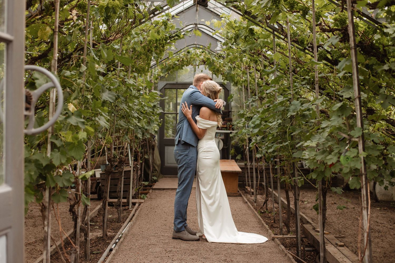 Romantic wedding photos taken inside a greenhouse with natural lighting.