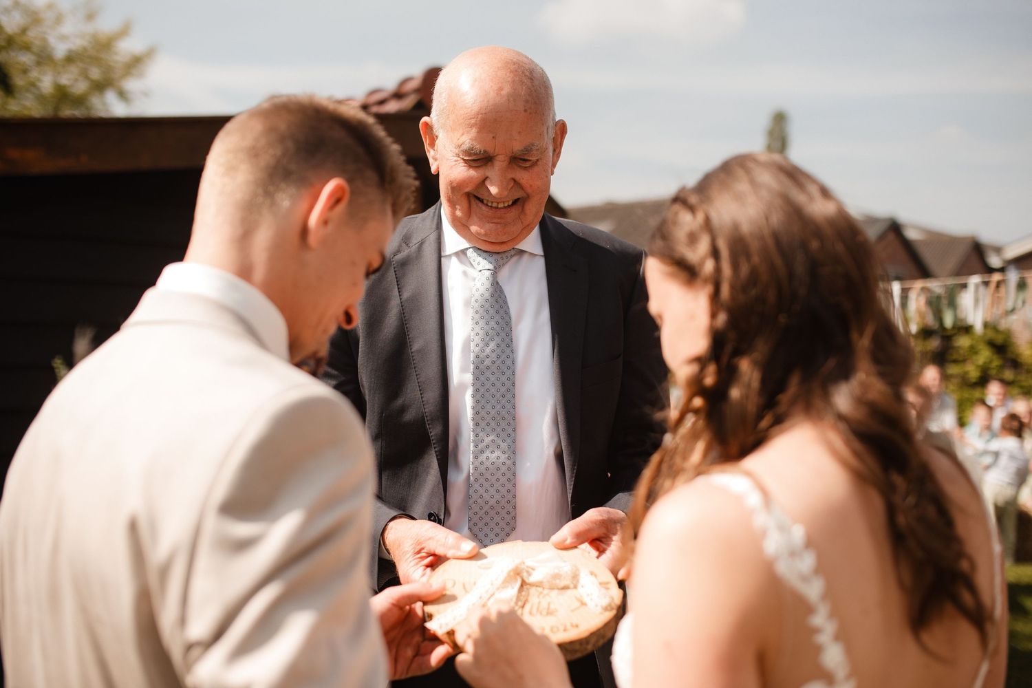 Wedding party members share joyful moments during an outdoor celebration.