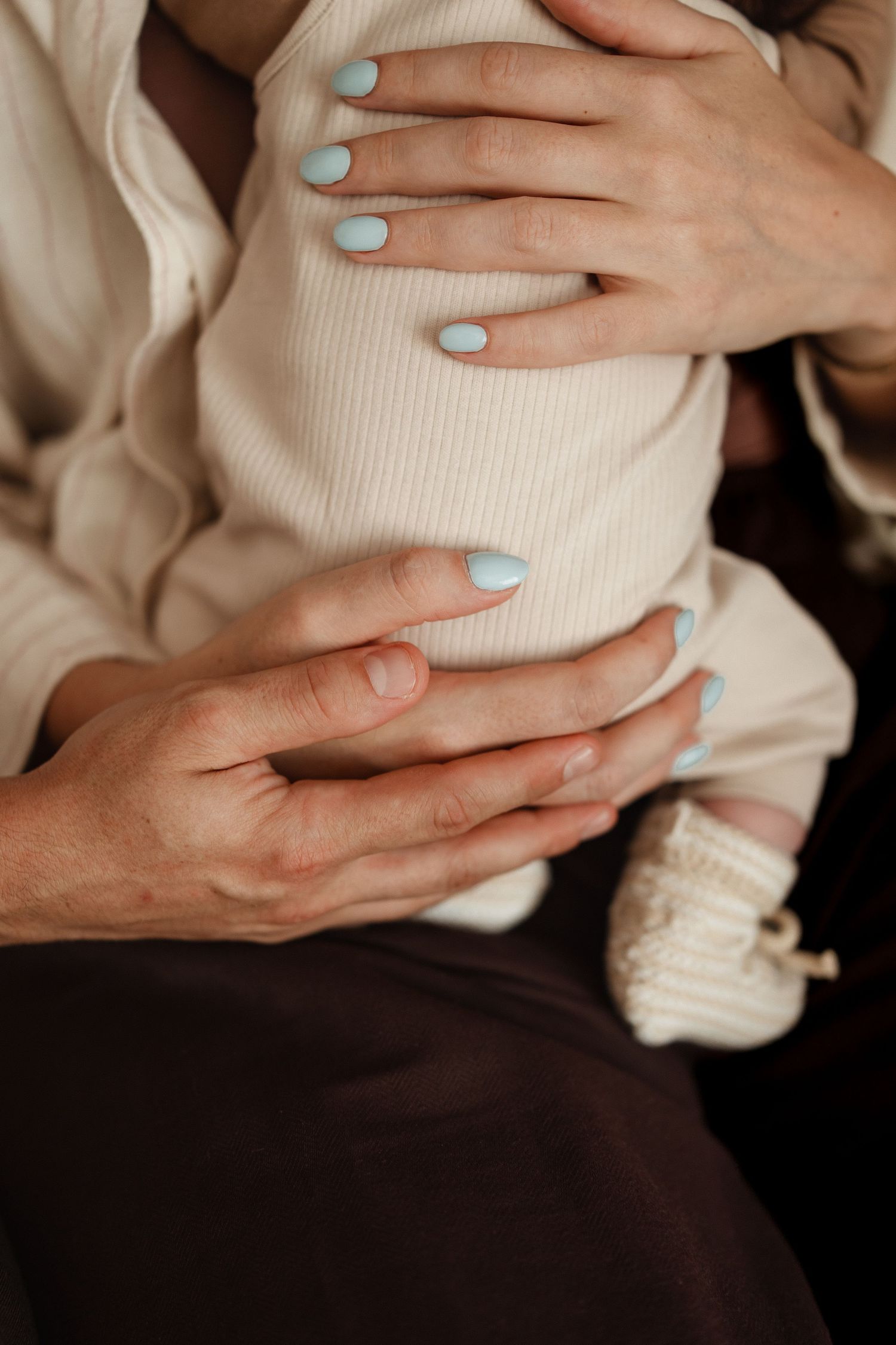 Detailfoto van handen rondom de billen van de newborn