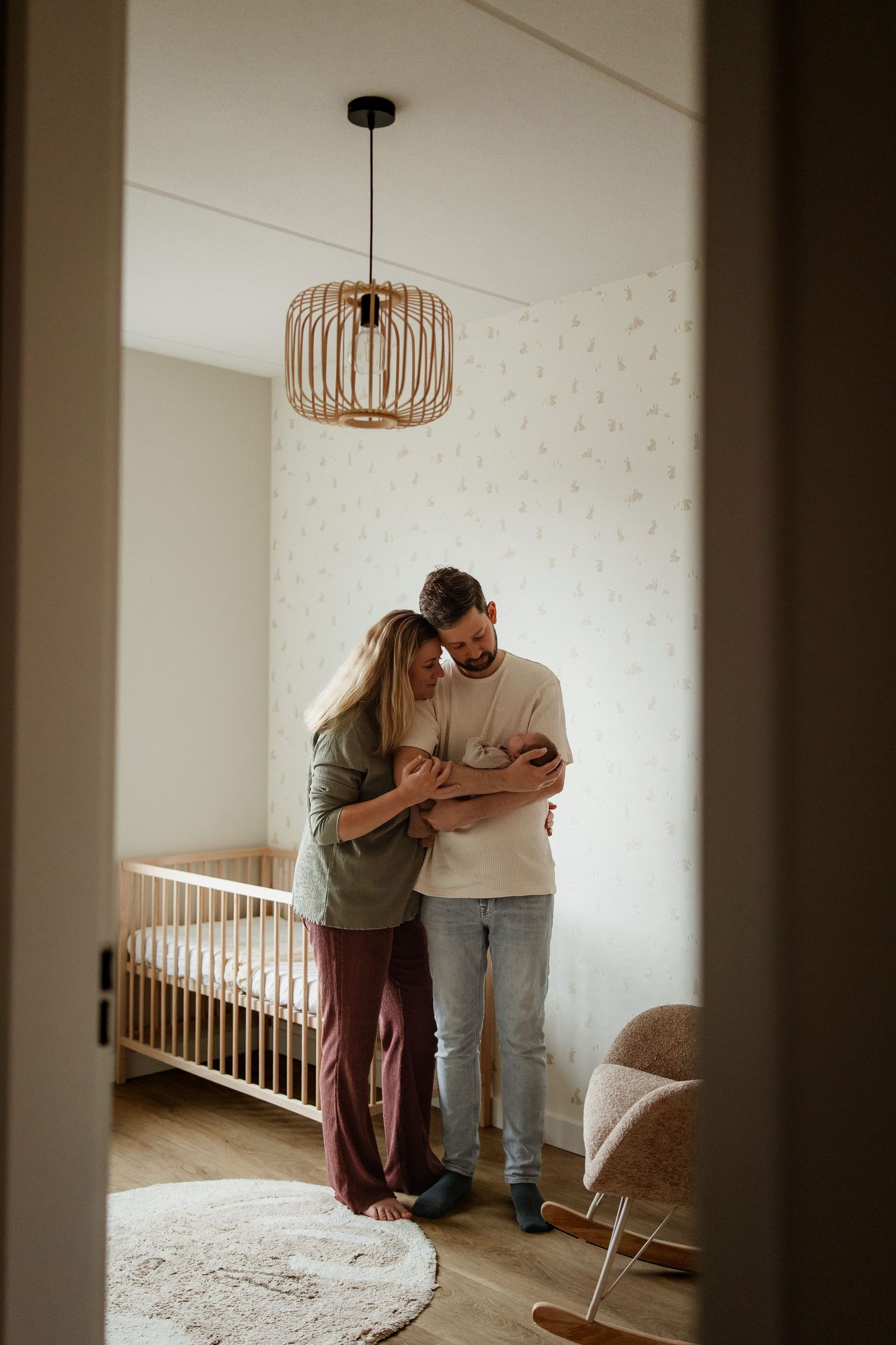 Kersverse ouders staan in het kamertje van hun pasgeboren dochter