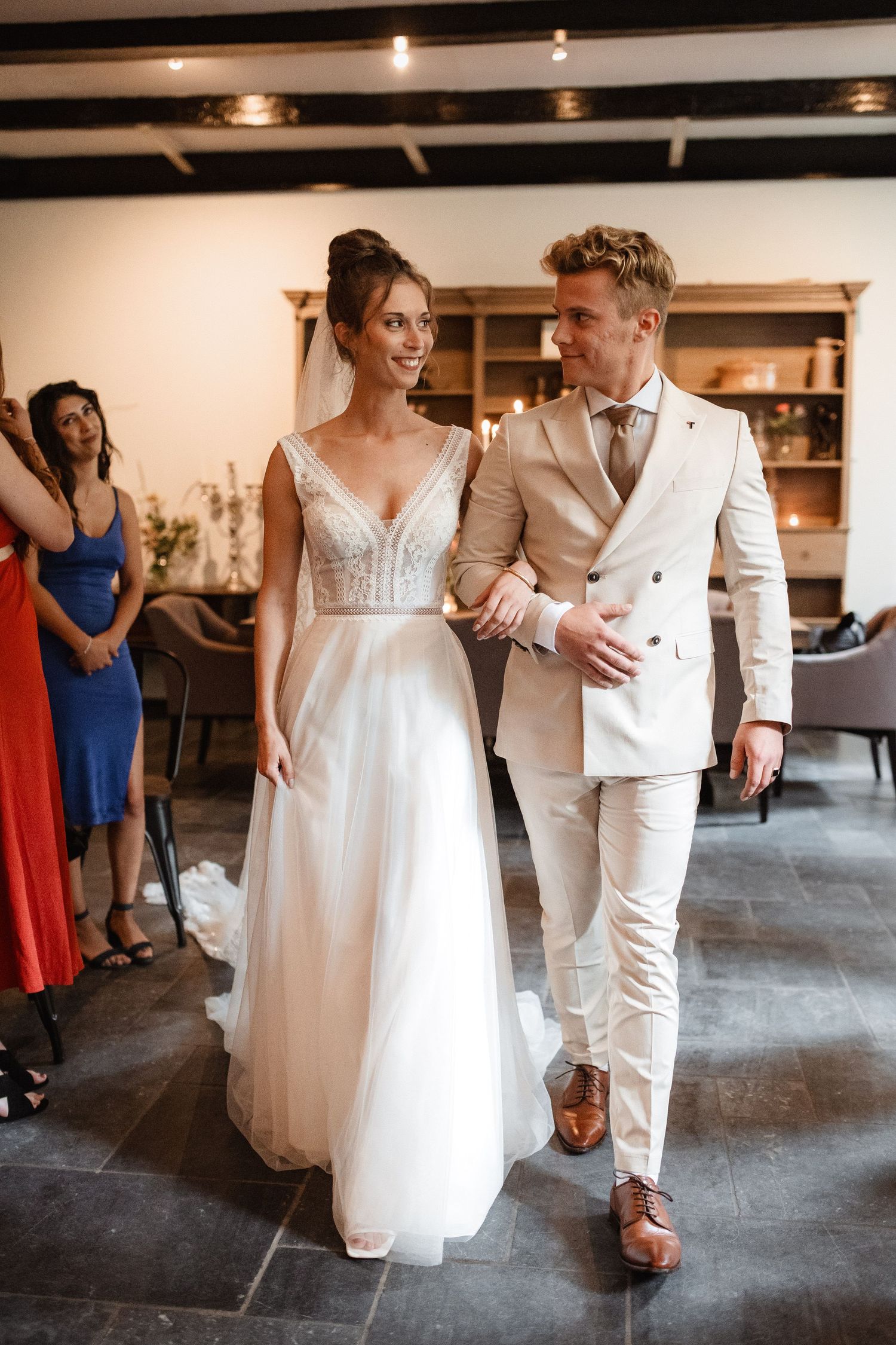 Wedding couple in white attire dancing and celebrating at their reception.