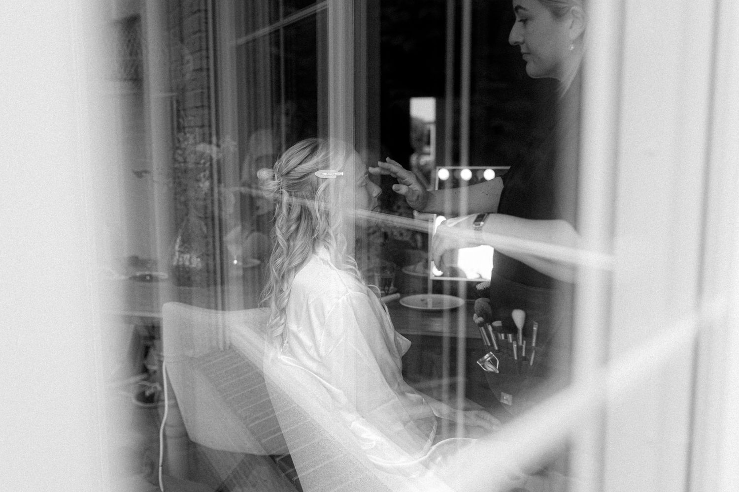 Artistic black and white wedding photography through window reflections.