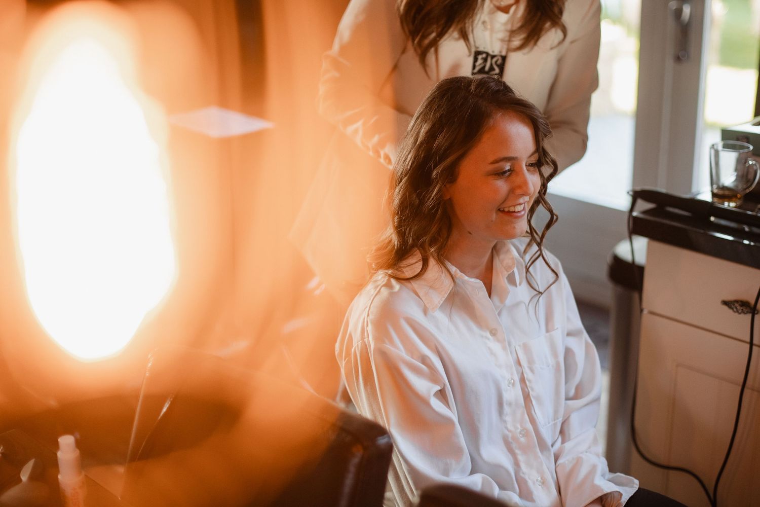 Warm sunlit scene with soft focus and orange tones during wedding preparations.