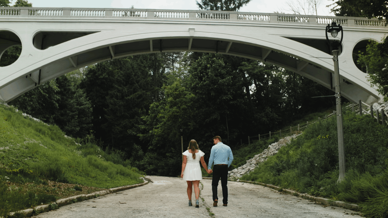 Engagement film of an engaged couple in an urban setting, looking at each other with love.