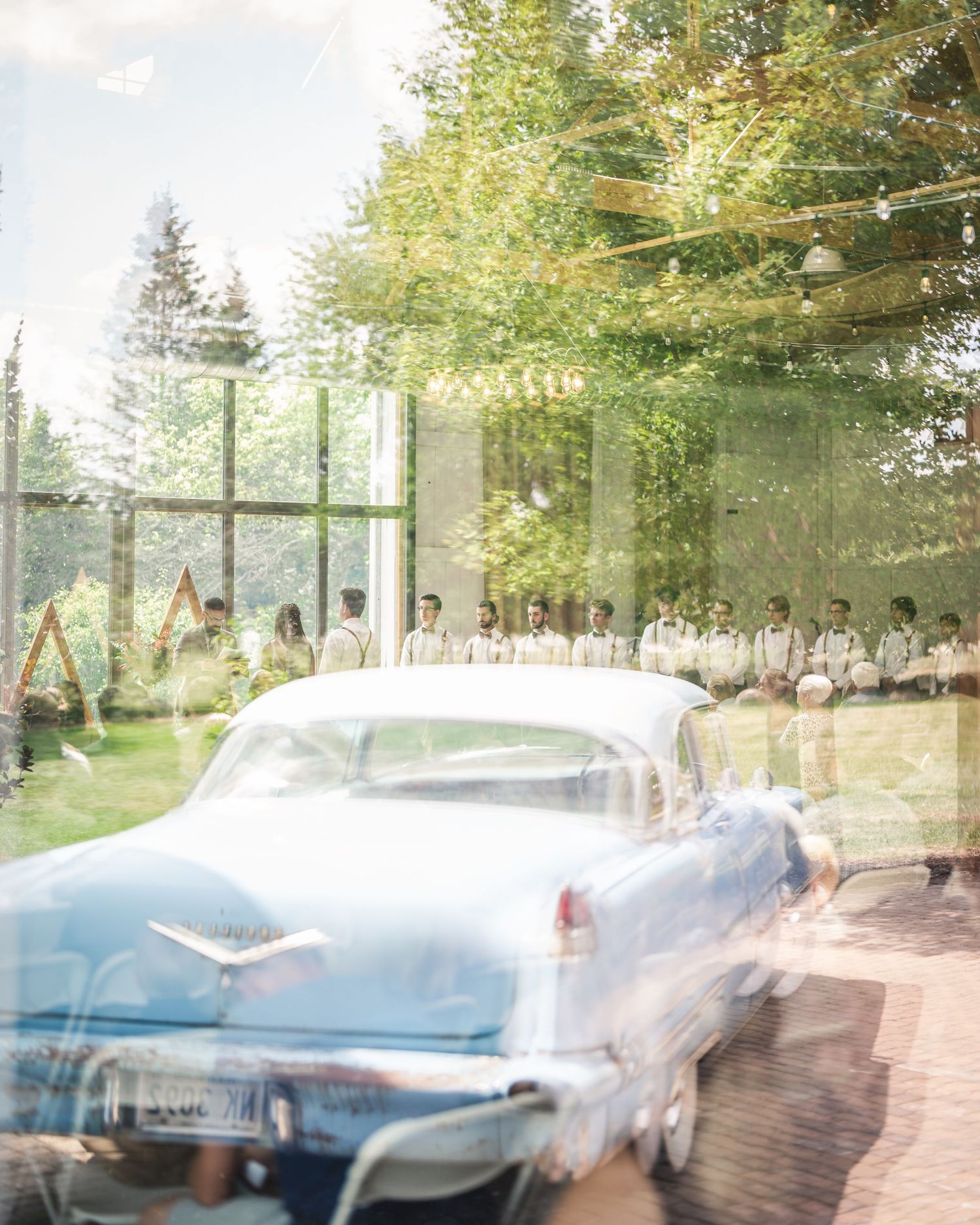 Vintage blue car parked outside wedding venue with dreamy double exposure effect.