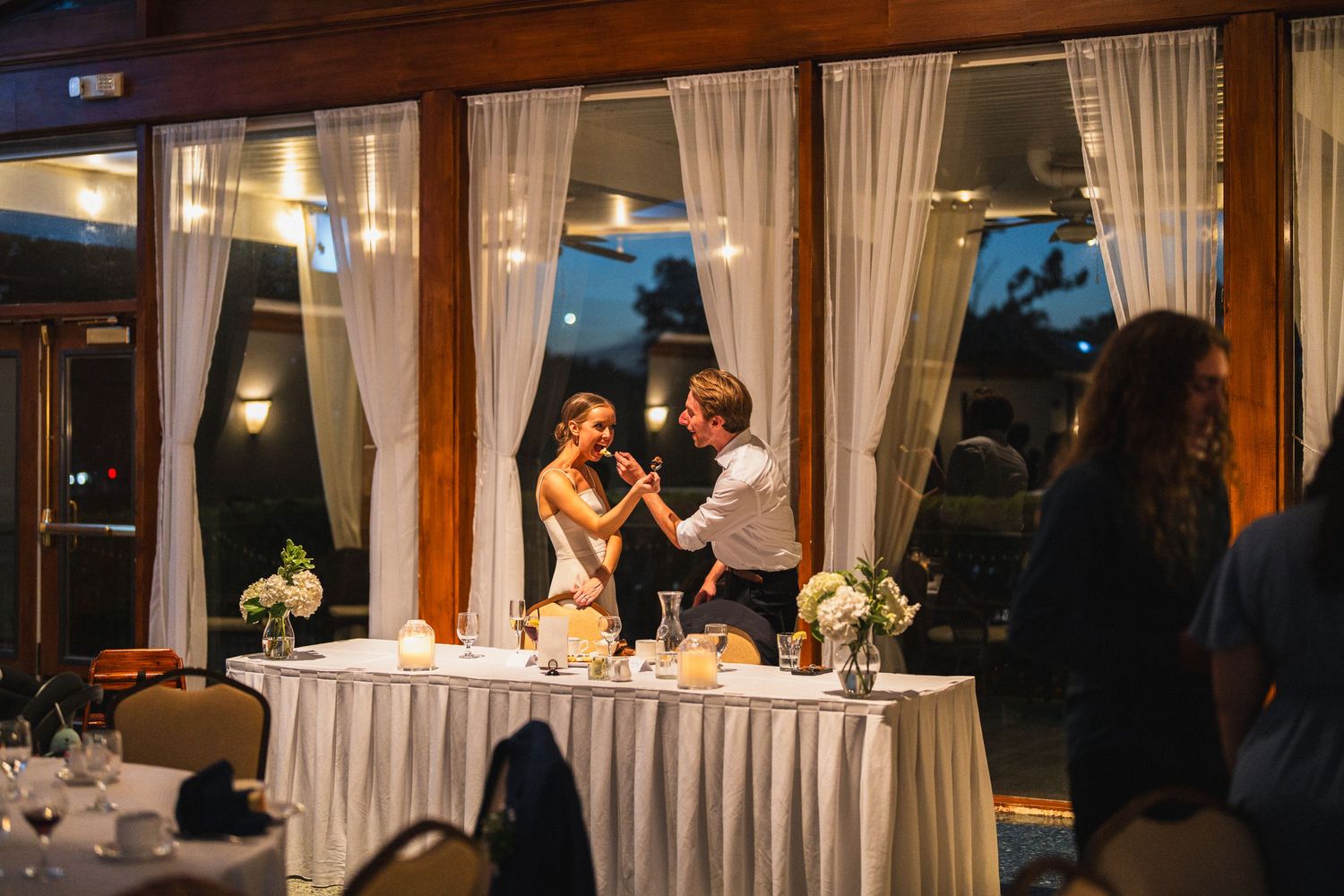 Bride and groom share their first dance near the sweetheart table at an elegant evening reception.