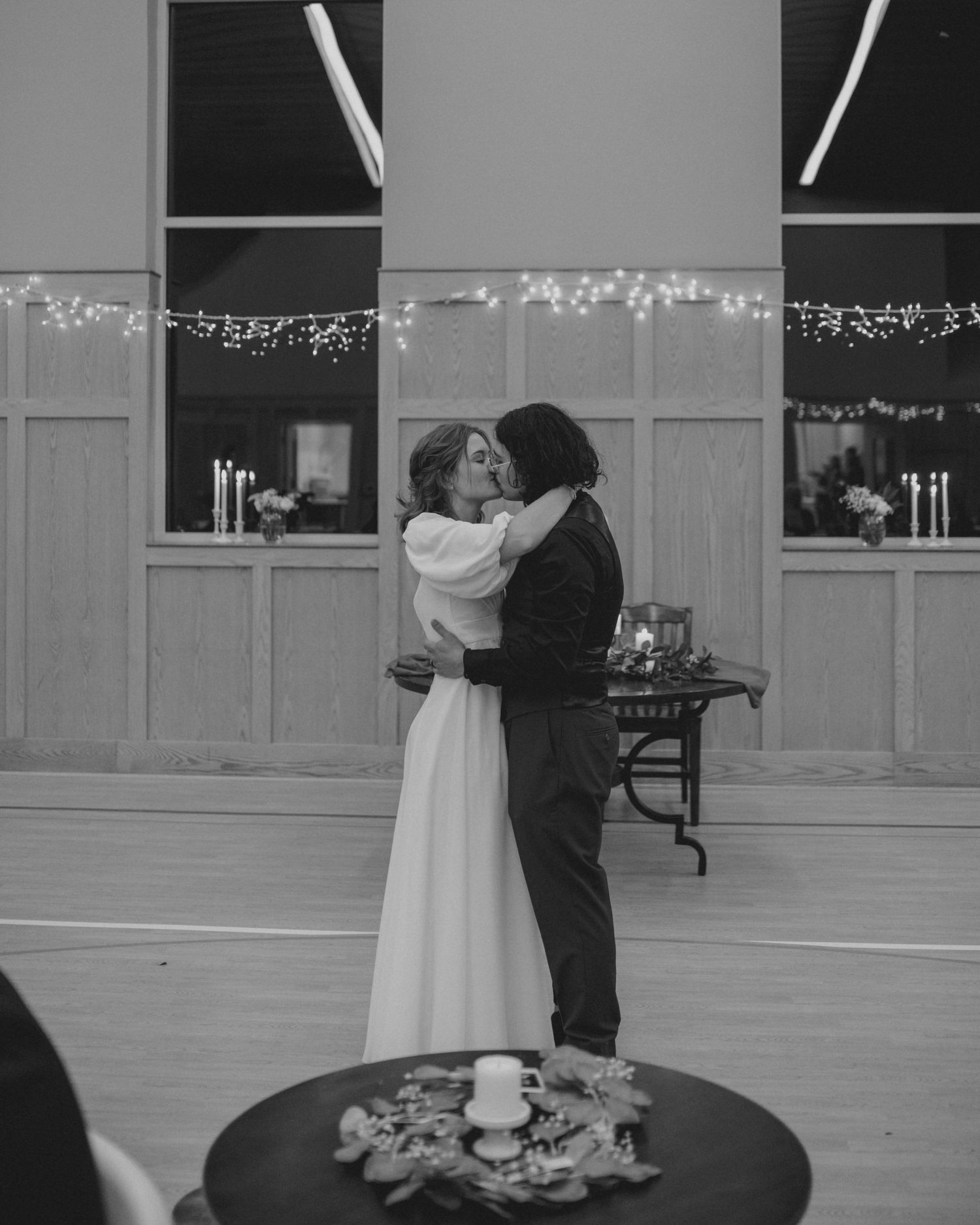 A romantic slow dance moment captured in black and white at a wedding reception.