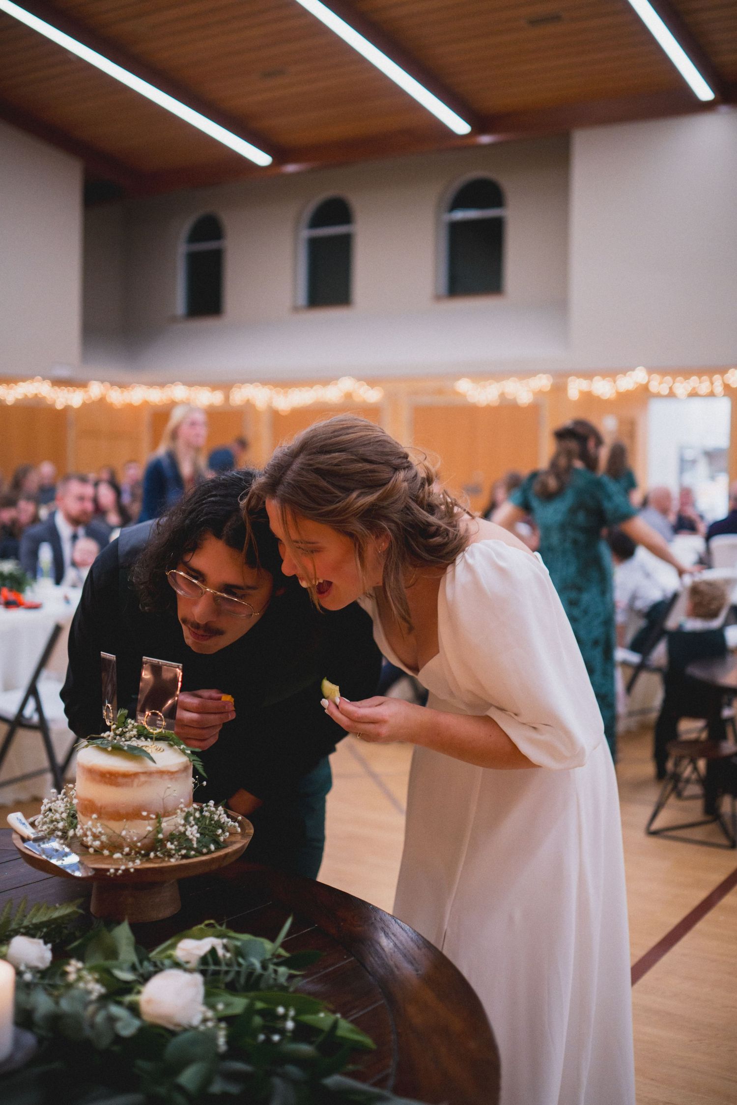 A couple examines their wedding cake together at the reception.