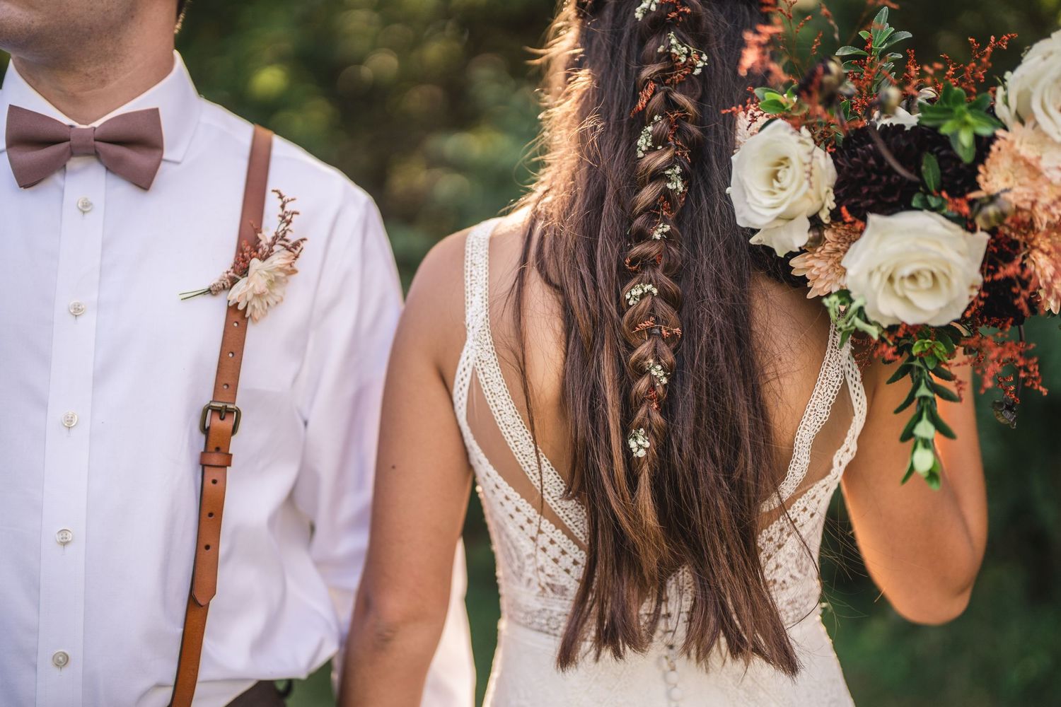 Close-up details of a bride and groom's wedding attire featuring brown suspenders and a bow tie.