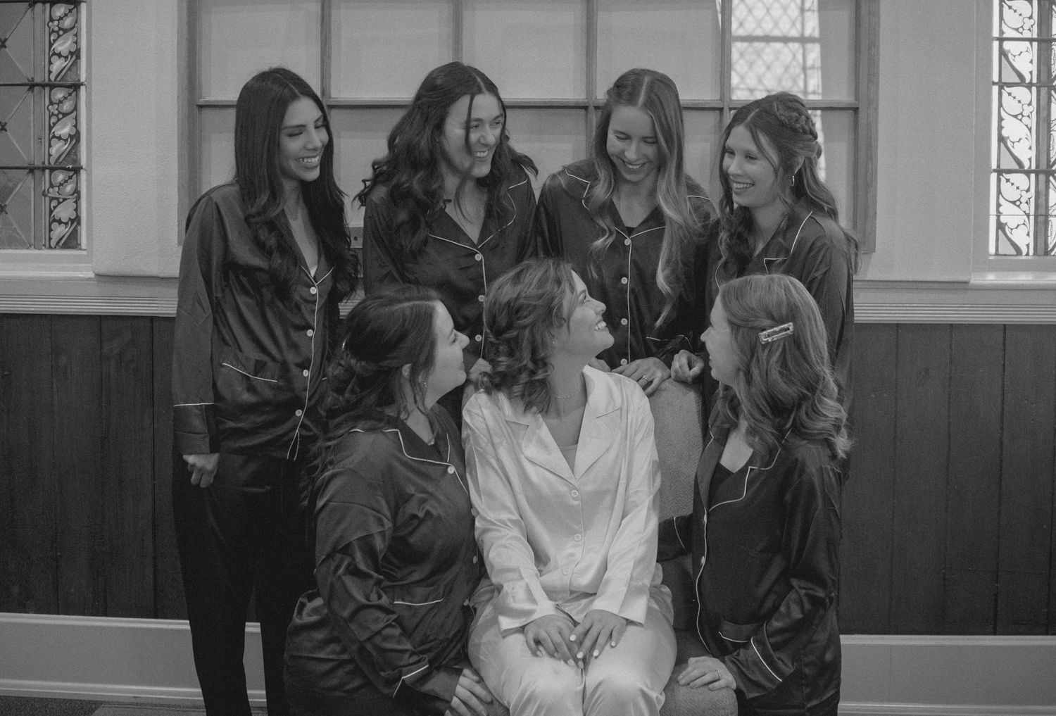 Black and white photo of wedding party members in matching robes posing together.