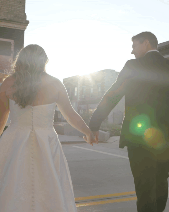 Wedding film of a married couple running, spinning and kissing during a beautiful, warm sunset.
