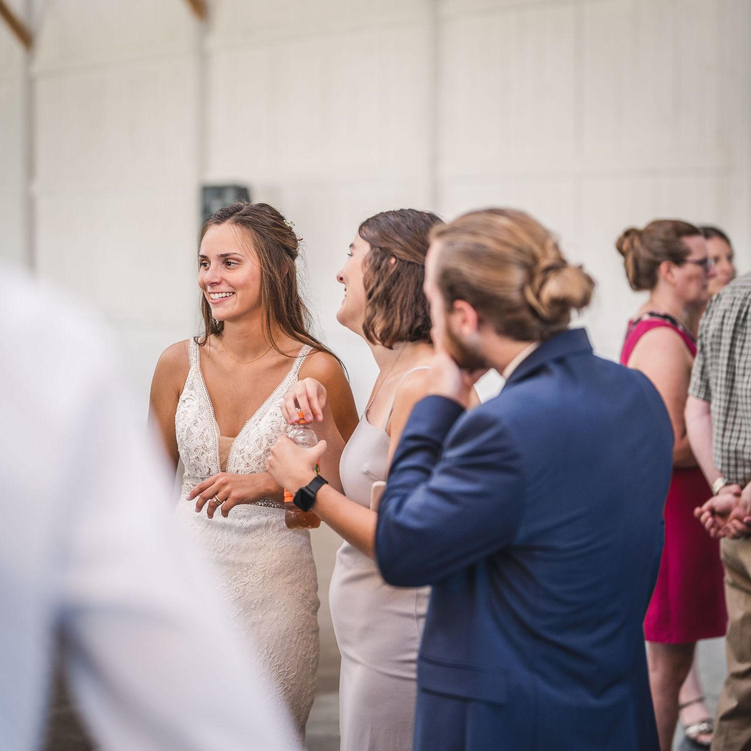 Wedding reception guests dancing and celebrating in an indoor venue.